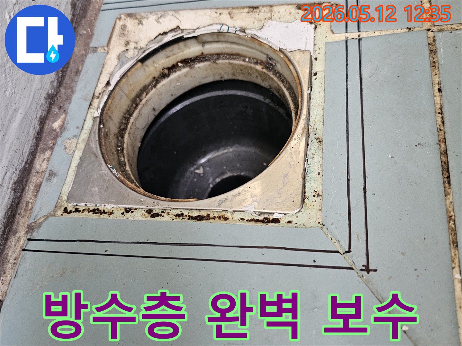 이 사진은-수원 영통 지역의-오래된 하수구 주변의-방수층 보수를 위한-초기 준비 단계와-정확한 작업 범위를-보여주고 있습니다