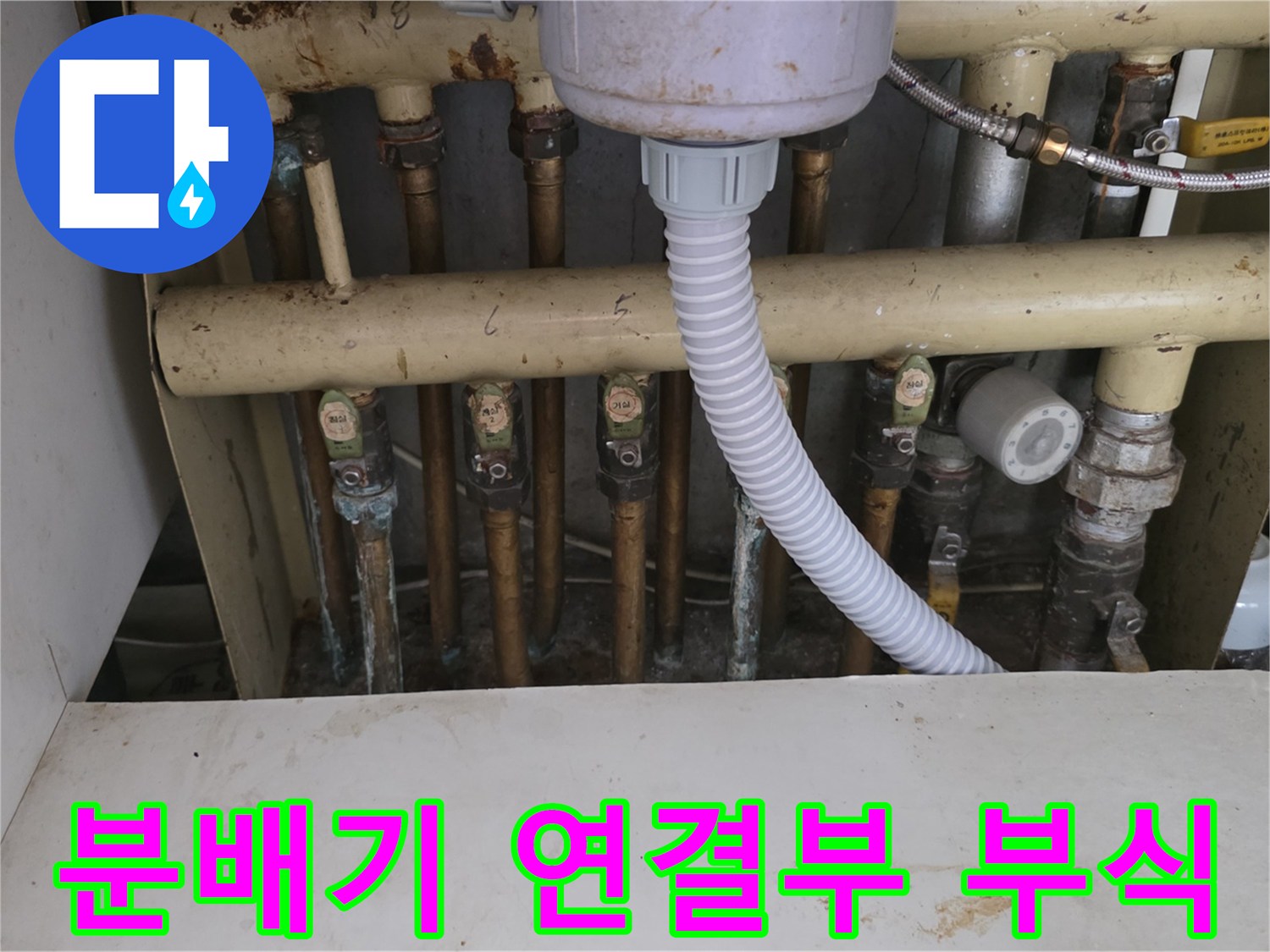 노후된 분배기 배관의 금속 너트와 접합부 부식 상태를 찍은 사진입니다.