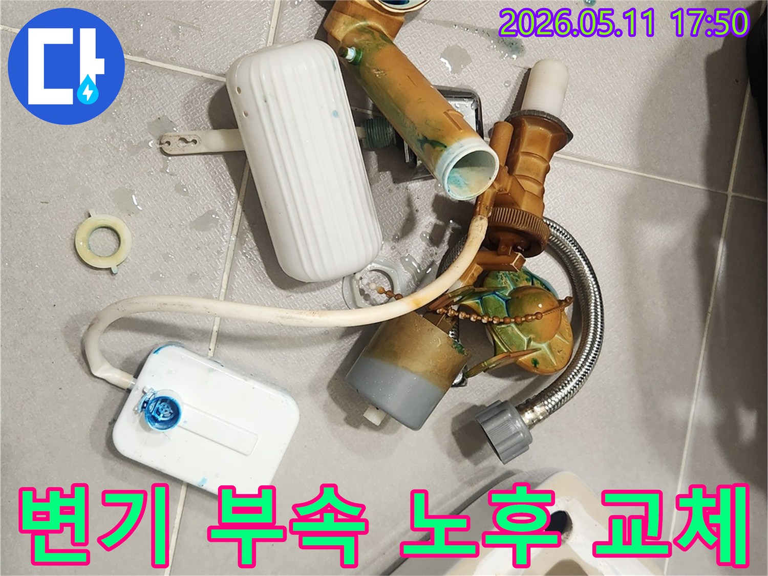 안방 변기에서 발견된 누수 문제로 인해-오래된 변기 부속들이 해체되어 바닥에 놓여 있습니다-새 부품으로 교체하여 문제를 해결할 예정입니다