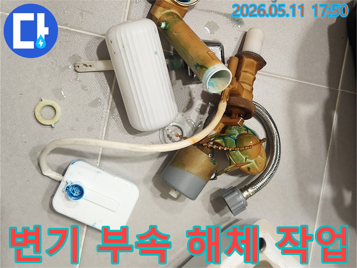 안방 변기에서 발생한 물샘 문제를 해결하기 위해-오래된 변기 부속들이 해체되어 바닥에 놓여 있는 모습입니다-새 부품으로 교체하여 변기를 수리할 예정입니다