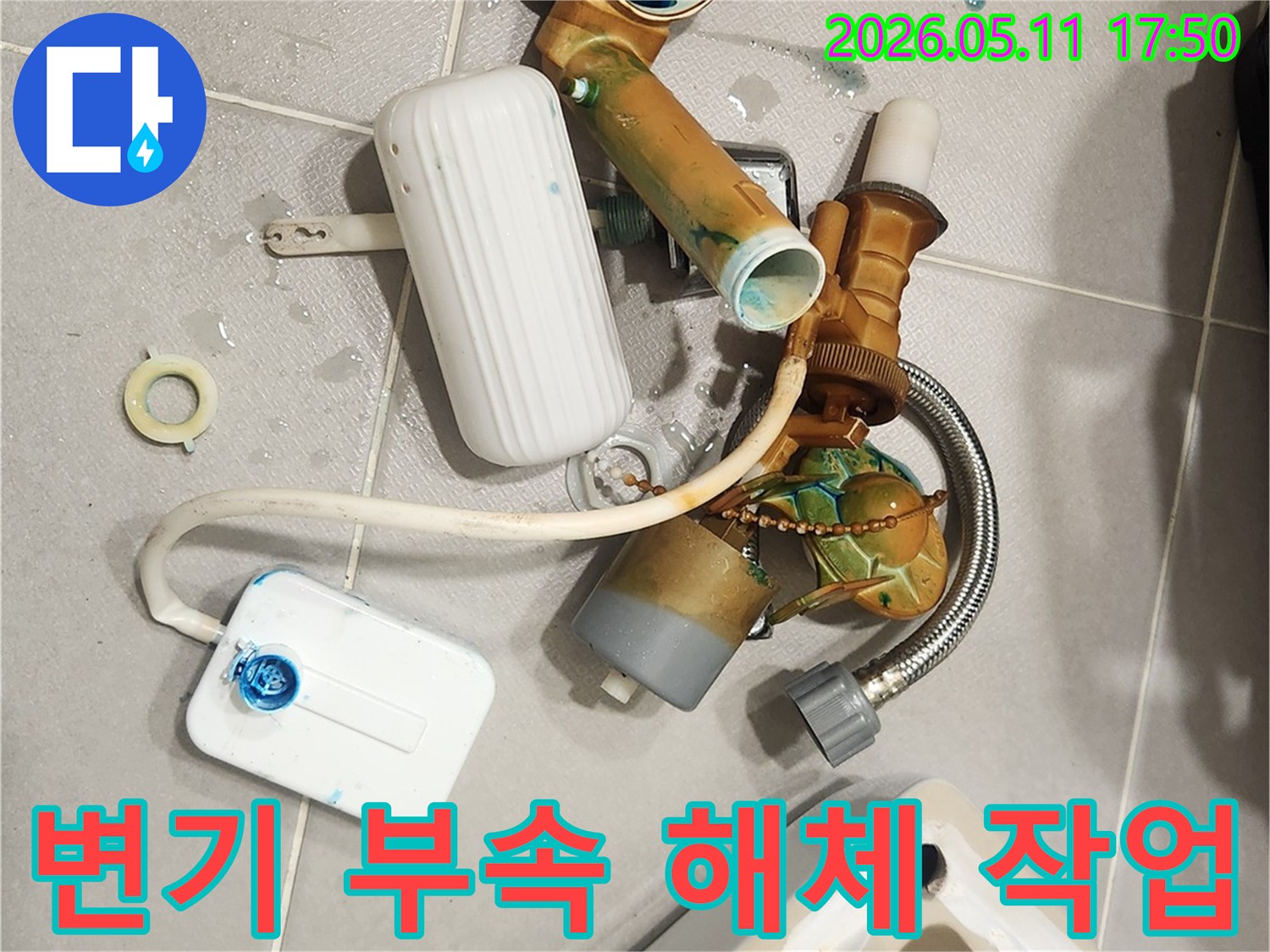 안방 변기에서 발생한 물샘 문제를 해결하기 위해-오래된 변기 부속들이 해체되어 바닥에 놓여 있는 모습입니다-새 부품으로 교체하여 변기를 수리할 예정입니다