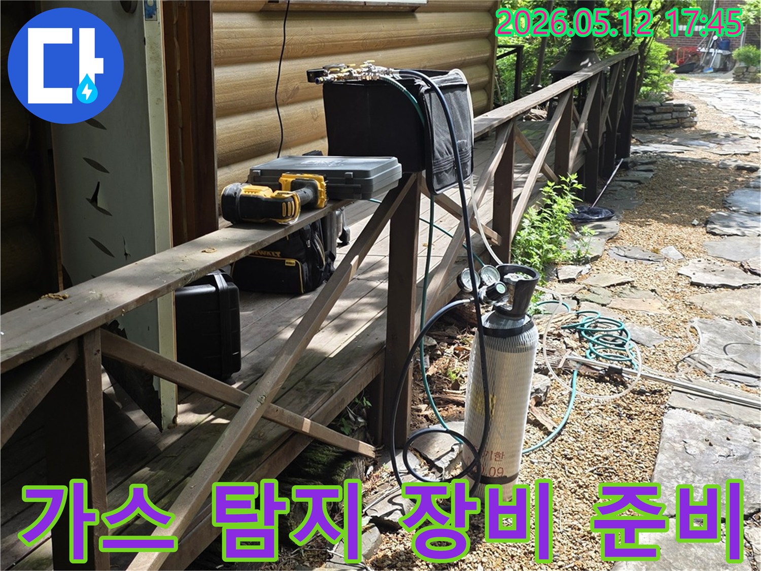 누수 탐지를 위한-가스통과 전문 도구들이-주택 옆 경사면에-정돈되어 있는 모습