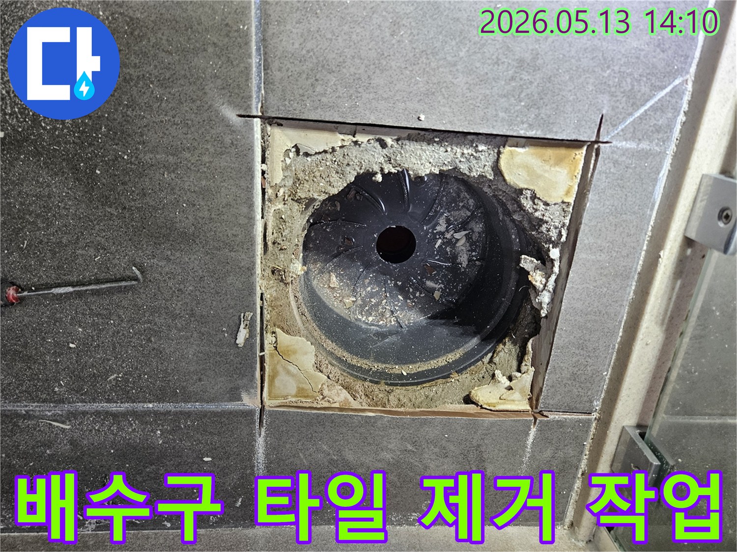 욕실 바닥 누수 원인을 파악하고 공사를 진행하기 위해-배수구 주변의 타일을 조심스럽게 제거하는 작업 현장입니다