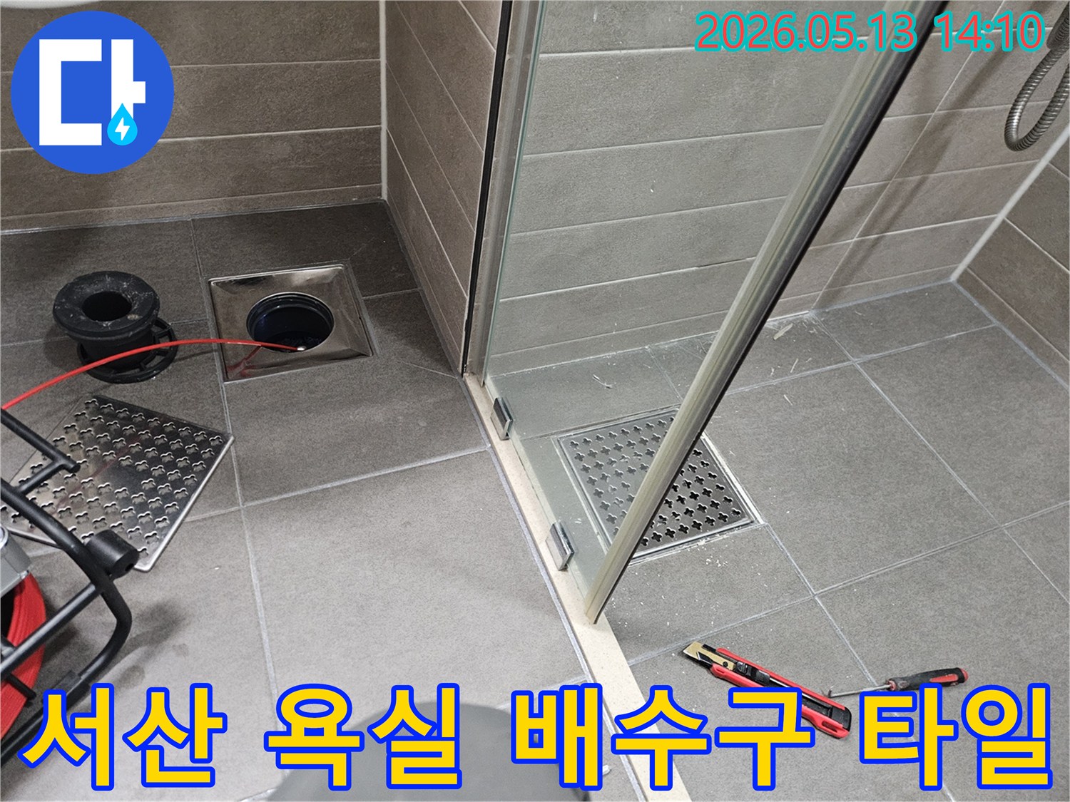 충남-서산-성연면-아파트-욕실에서-누수가-의심되어-전문가가-배수구-주변-타일을-정밀-점검하는-모습입니다.