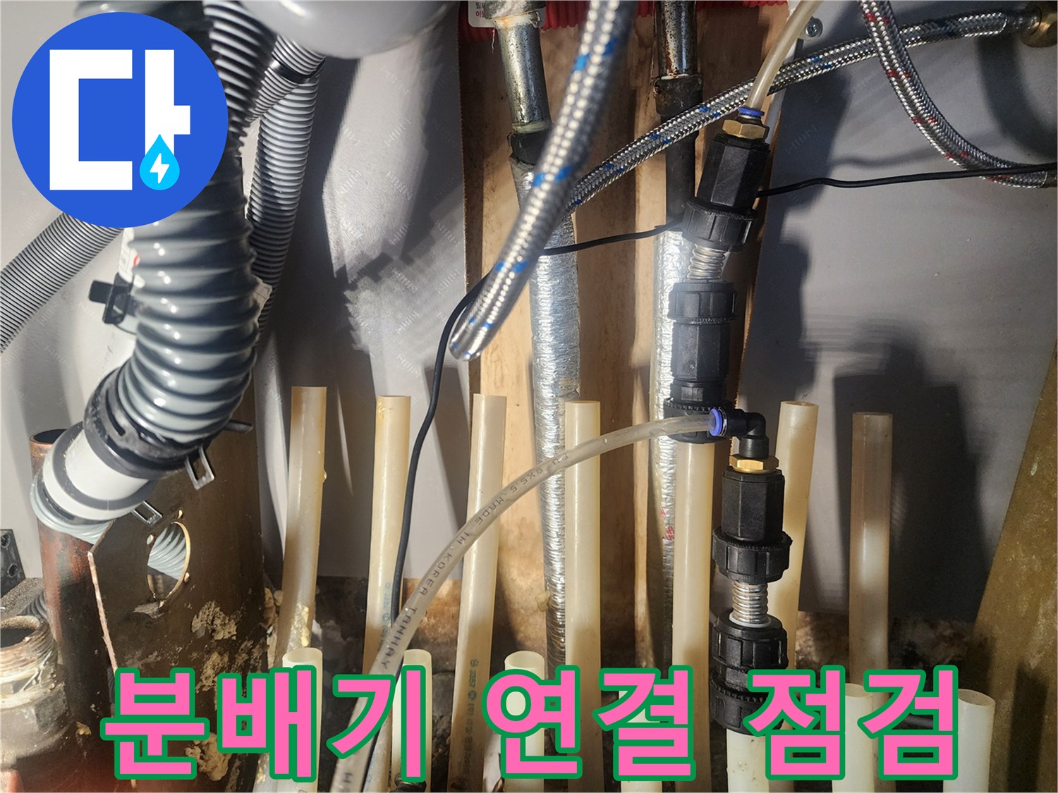 난방 배관 분배기 연결부에 테스트 장비를 연결하여-누수 여부를 정밀하게 점검하는 모습입니다.