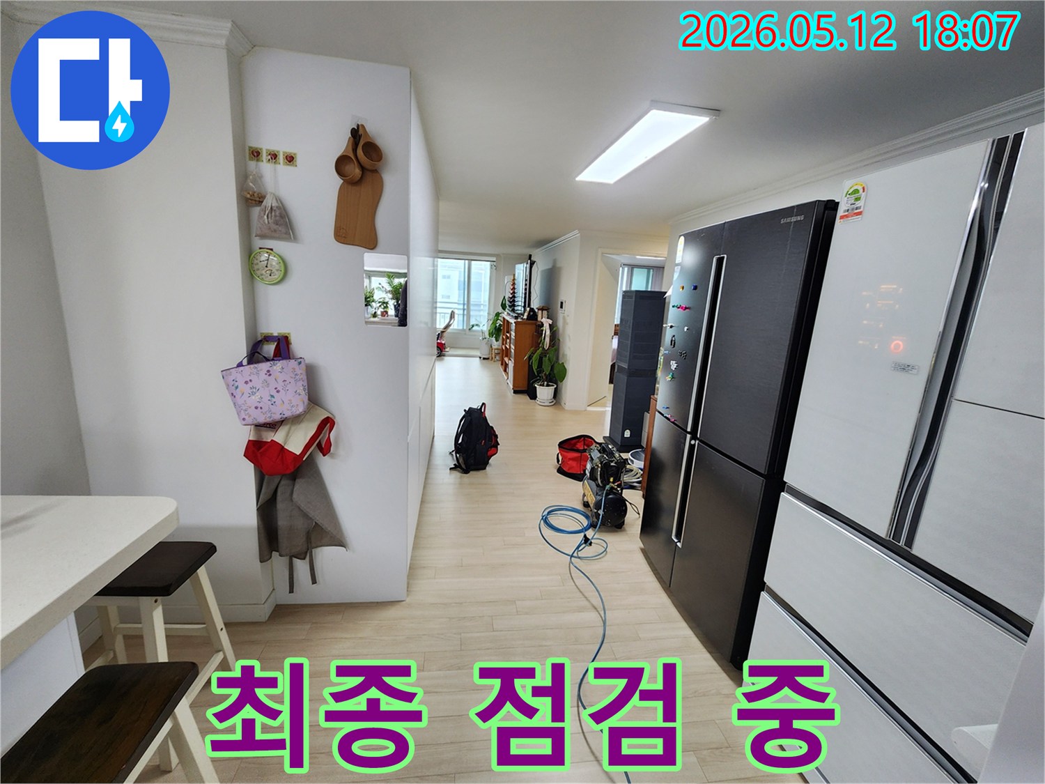 아파트 거실에-누수 탐지용 공압 장비가-설치되어 있고-최종 점검 중인 현장