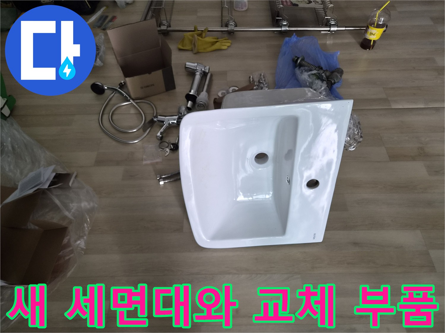 교체를 위해 준비된 새 세면대와 배관 트랩 및 수전 부속들입니다.