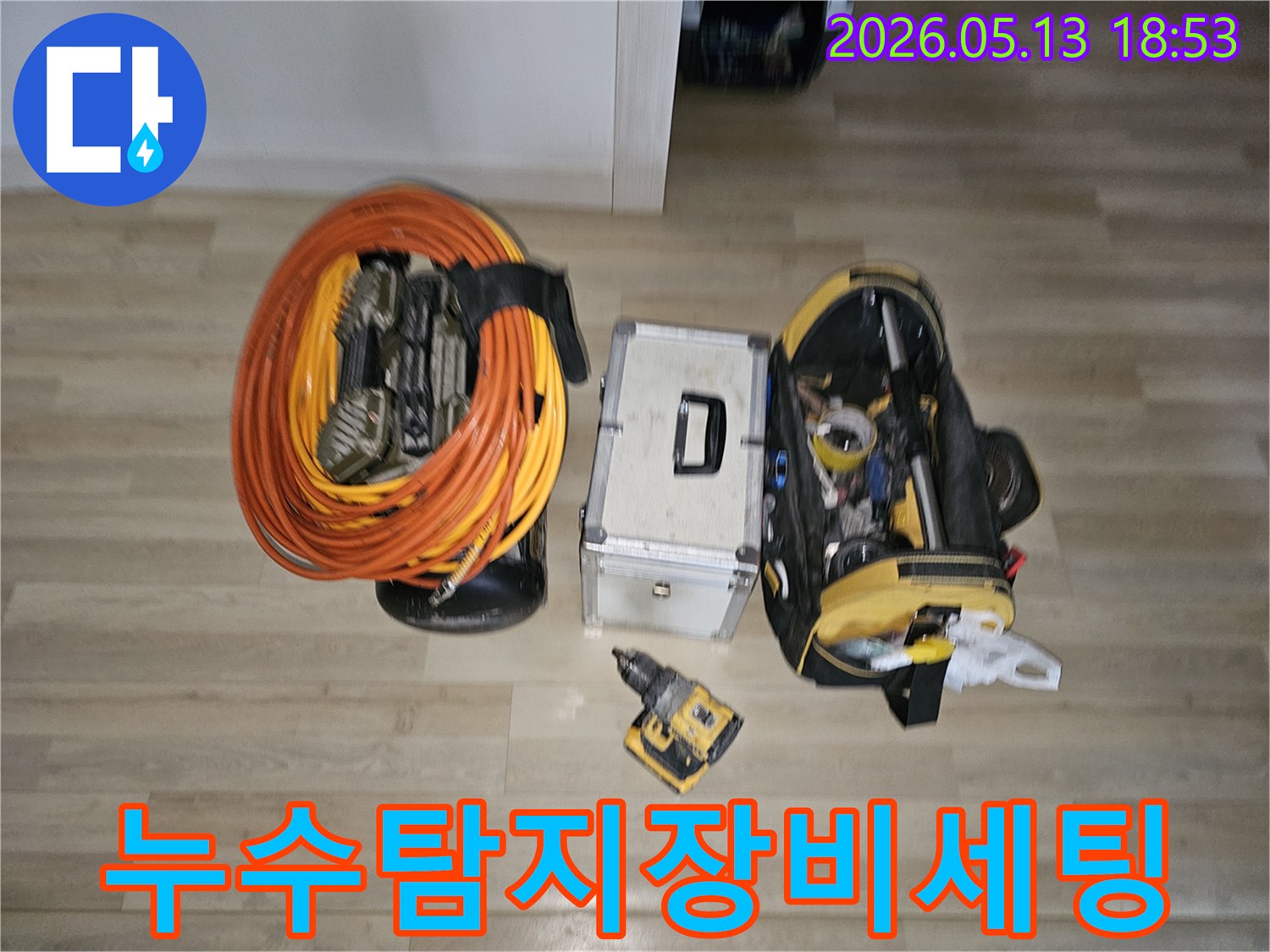 누수 공사에 사용될 다양한 도구들이 바닥에 정돈되어 있습니다-정확하고 효율적인 작업을 위한 필수적인 준비물입니다.