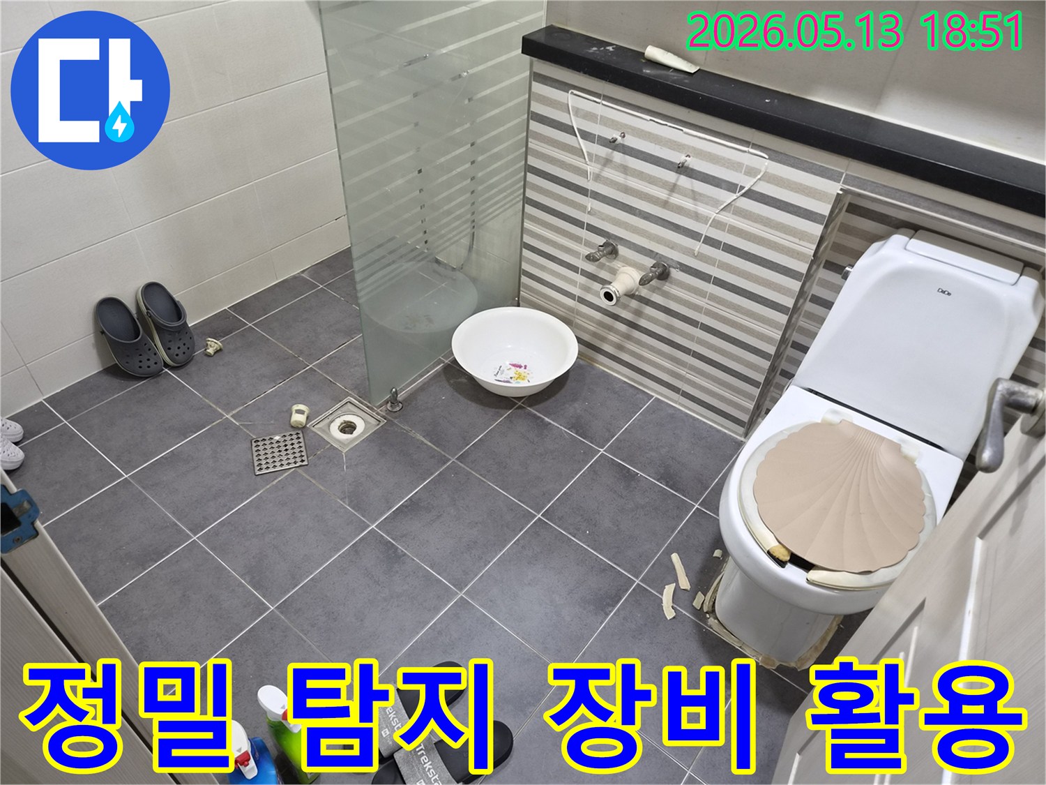 송도-럭키아파트-화장실-누수-현장에서-정밀-탐지-장비를-활용하여-바닥-타일-아래-누수-지점을-찾아내는-전문가의-모습
