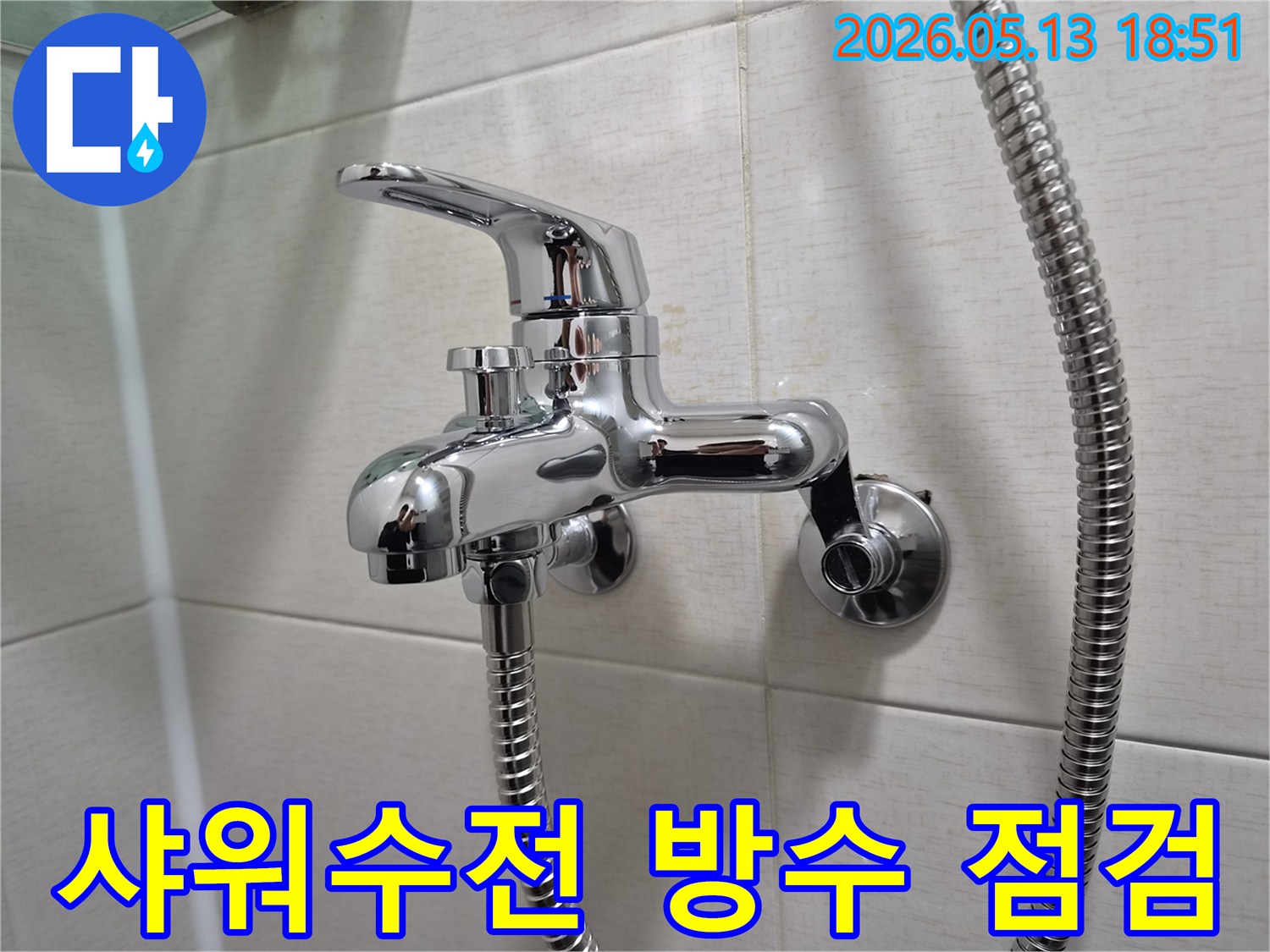 욕실 벽에 단단히 고정된 크롬 샤워 수전-주변 타일과 실리콘 마감 상태-벽체 누수 방지를 위한 세심한 점검
