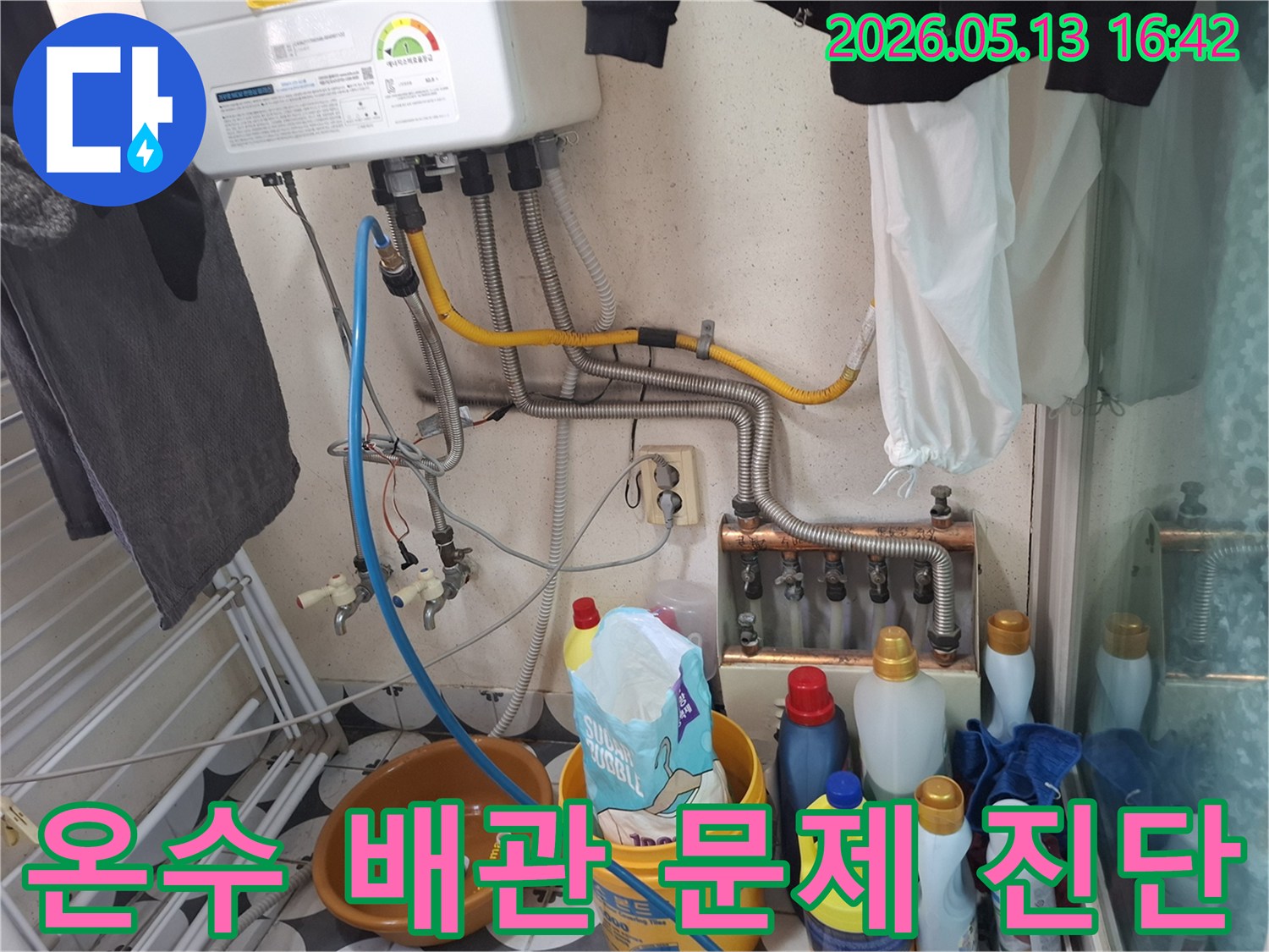 세탁실 보일러 하단부의-온수 배관 연결 지점에서-누수 여부를 확인하는 전문 기술자의 모습