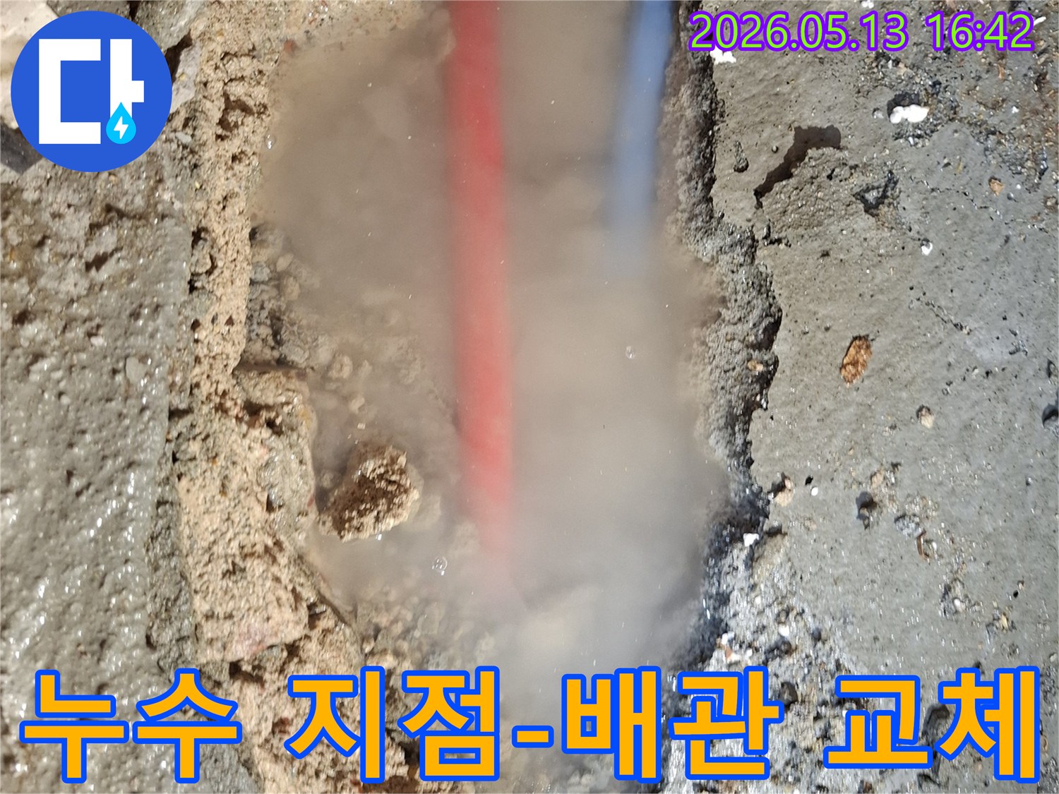 콘크리트 바닥을 파헤친 곳에서-흙탕물과 함께-붉은색과 푸른색 배관이 드러나고-뜨거운 물이 새는지-수증기가 피어오르는 모습