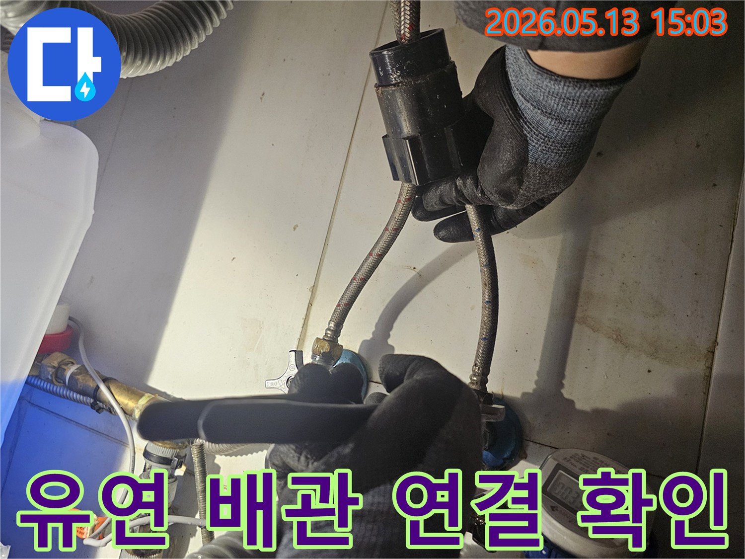 전문 기술자가-유연한 수도 배관의-연결 부위를-꼼꼼하게 점검하며-누수 흔적을-찾아내고 있습니다