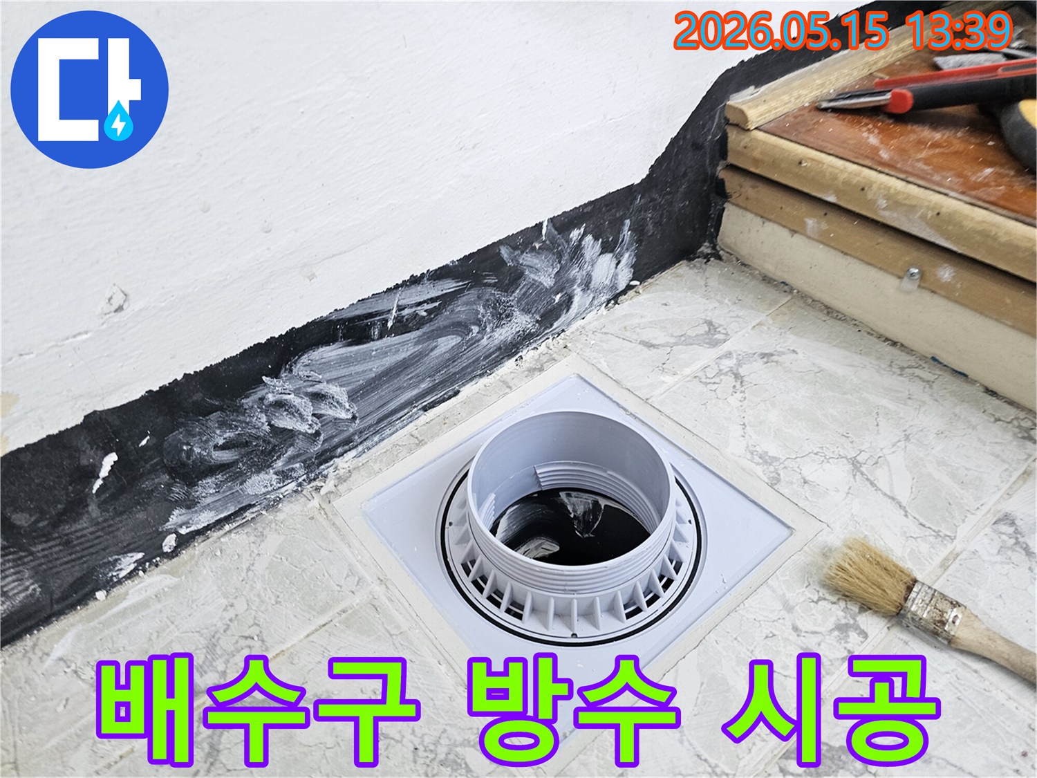 다세대주택 욕실의 배수구 주변에-방수층을 새롭게 시공하는 모습으로-누수 문제를 해결하고-건물의 안전을 확보합니다