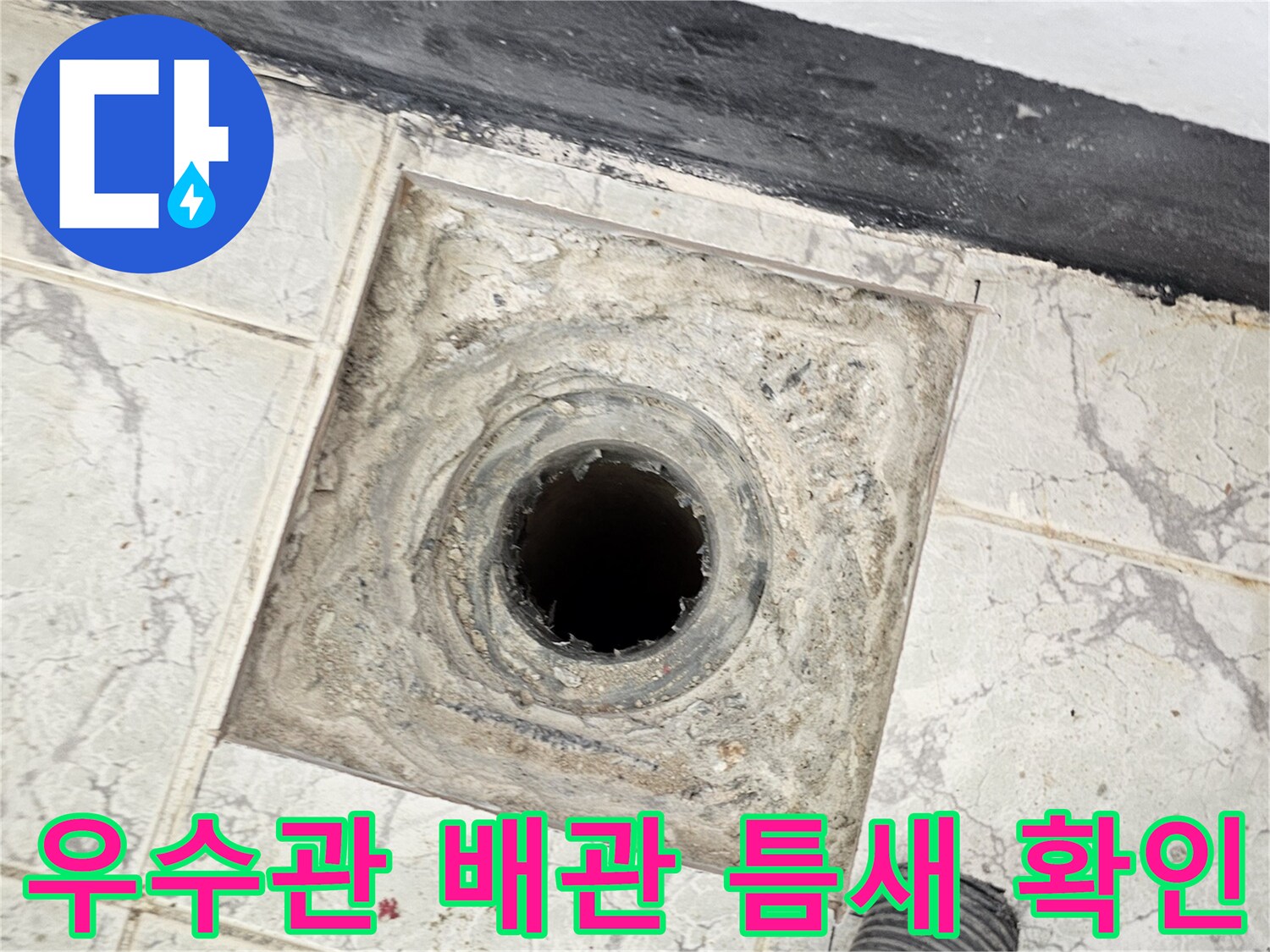 배관 주변의 오염된 콘크리트와 타일 사이 균열 부위