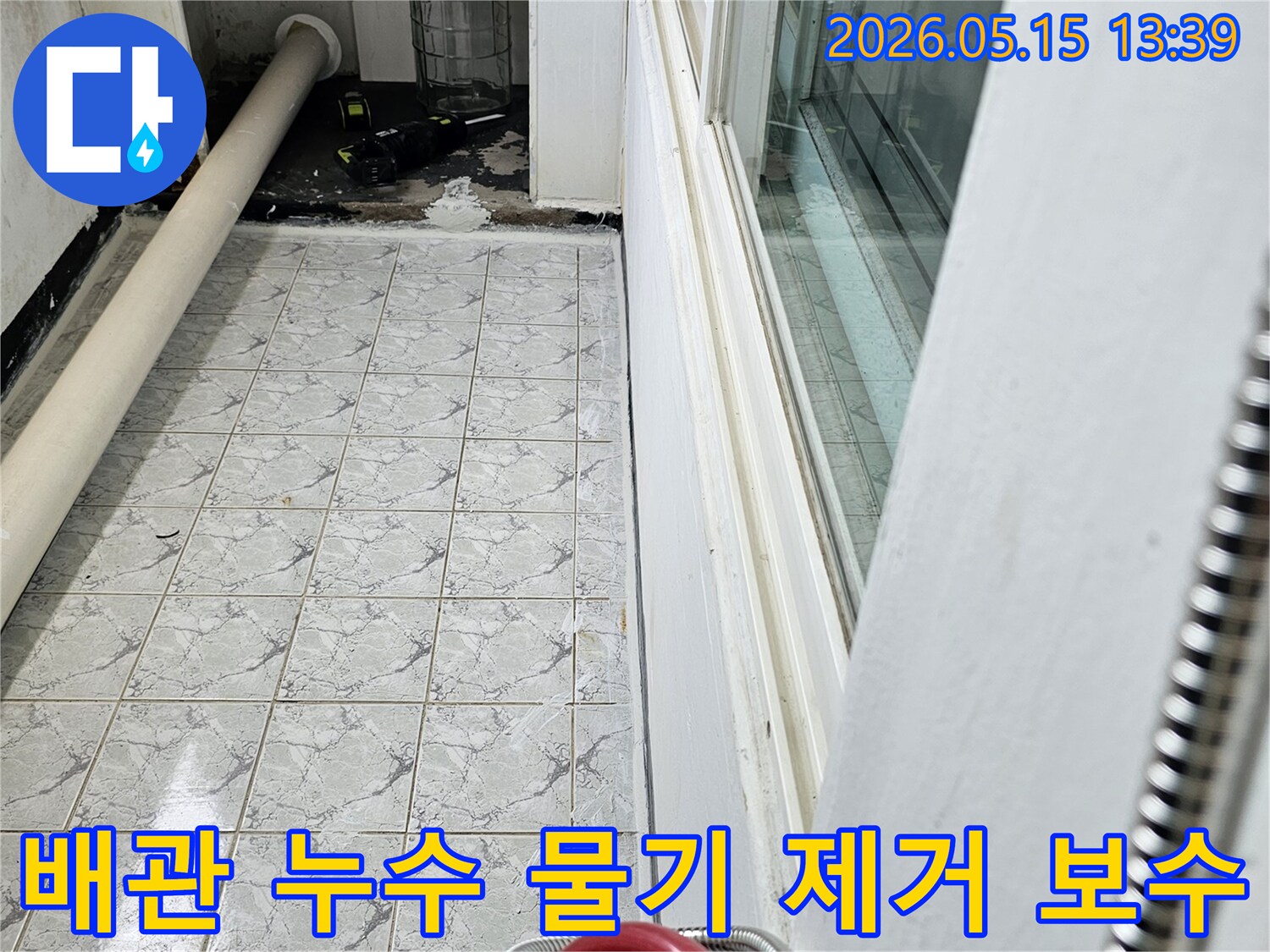 의정부 신곡동 아파트의 배관 누수로 인해 물이 고여 있는 현장을 보수하기 위해-물기를 제거하는 모습을 보여주는 사진입니다