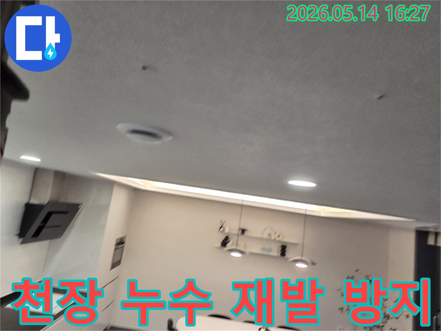 이 이미지는 주방 천장에 나타난-작은 물 얼룩과-환기구를 보여주며-아파트 누수 문제의-재발 방지를 위한-전문 시공의-중요성을 시사합니다