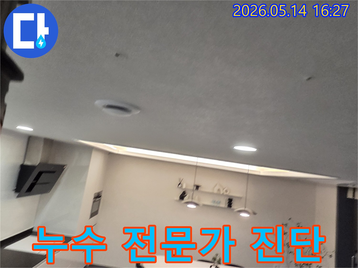 이 이미지는 주방 천장의-작은 물 얼룩과-환기구를 보여주며-누수 문제 해결을 위한-전문가의 정확한 진단과-책임감 있는 시공의-중요성을 강조합니다