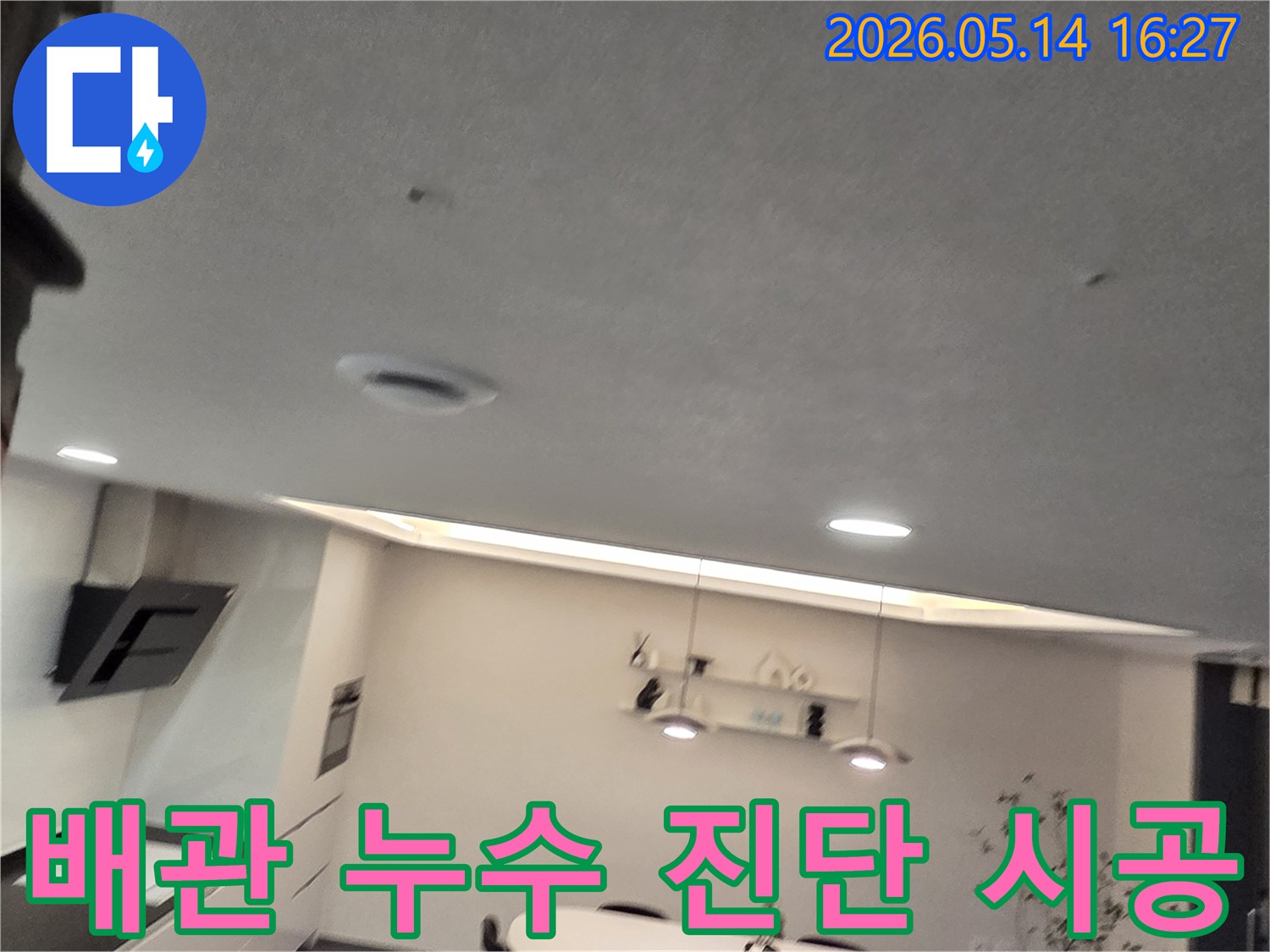 이 이미지는 주방 천장의-작은 물 얼룩과-환기구를 보여주며-배관 누수 문제의-정확한 진단과-전문 시공의-중요성을 강조합니다
