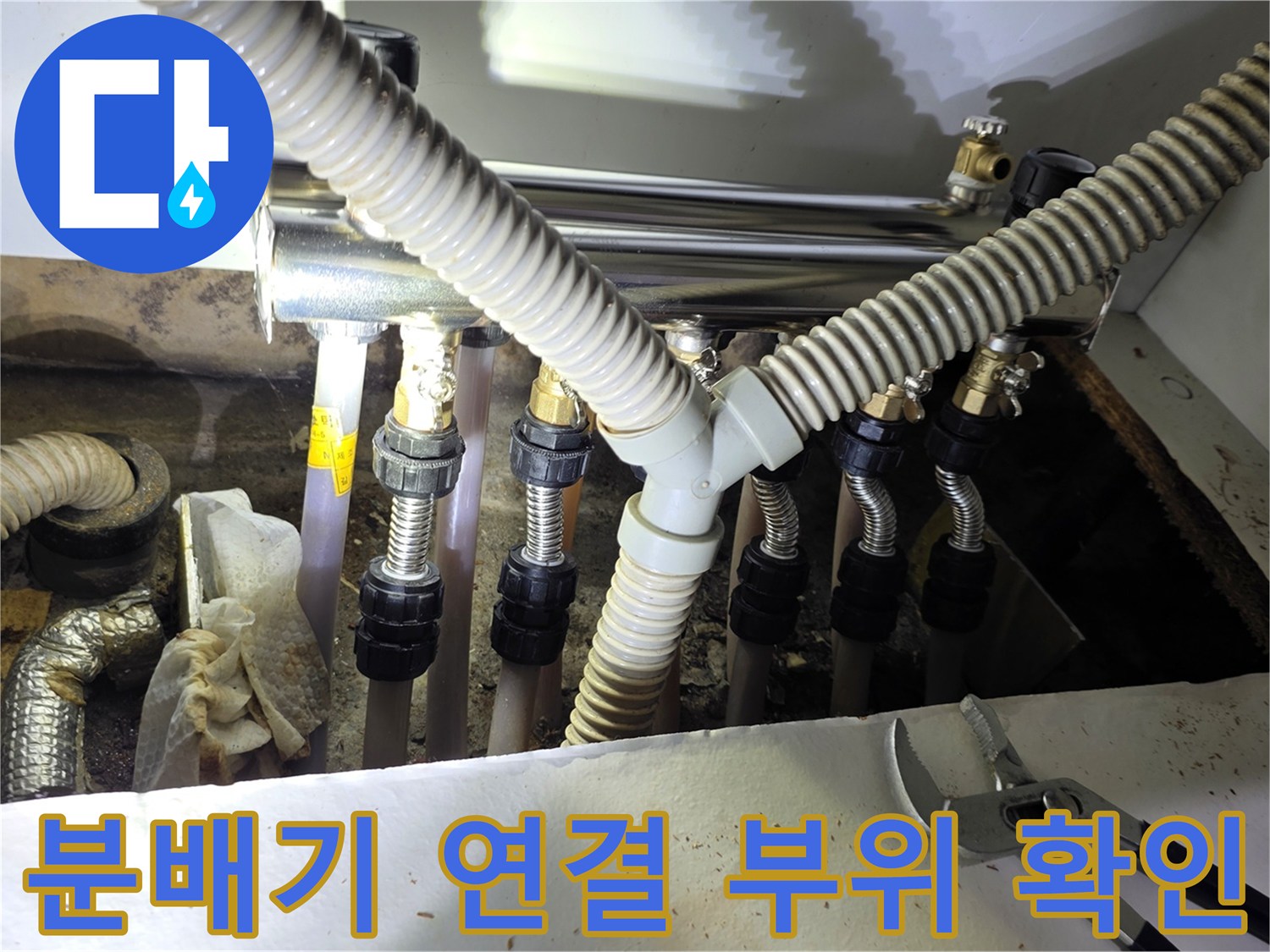 싱크대 하부 분배기에 연결된 주름관과 금속 부속품들의 모습