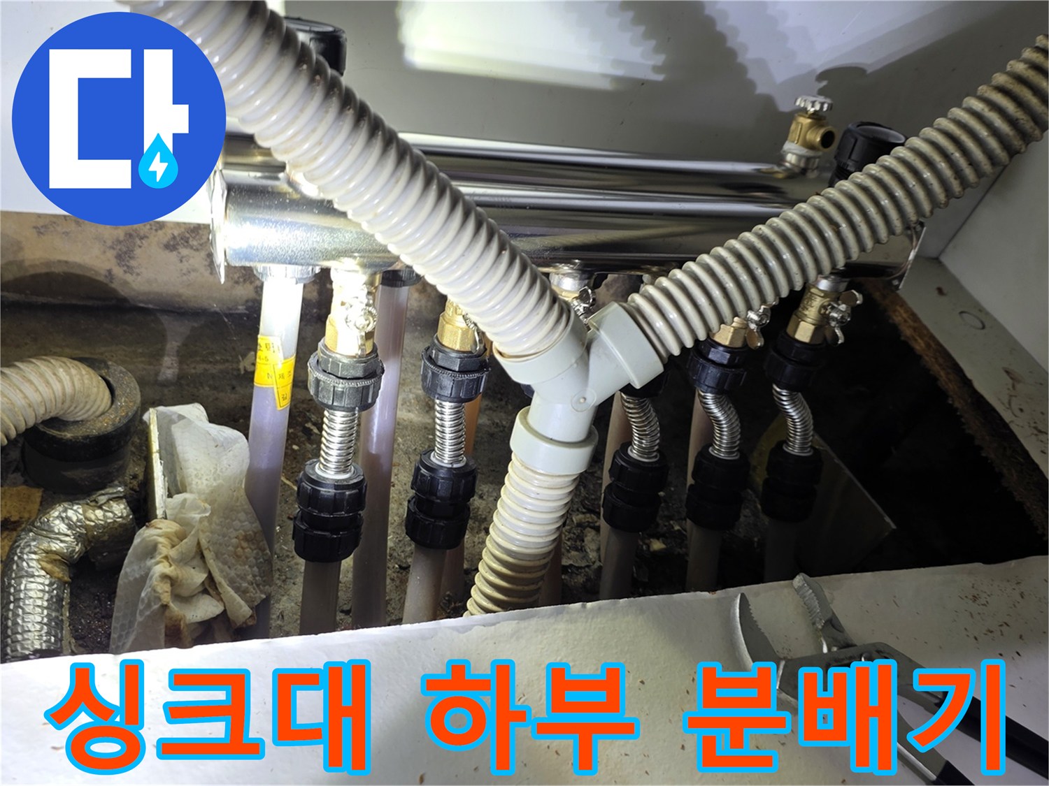주방 싱크대 아래 설치된 보일러 분배기와 주름관 연결 부위 모습