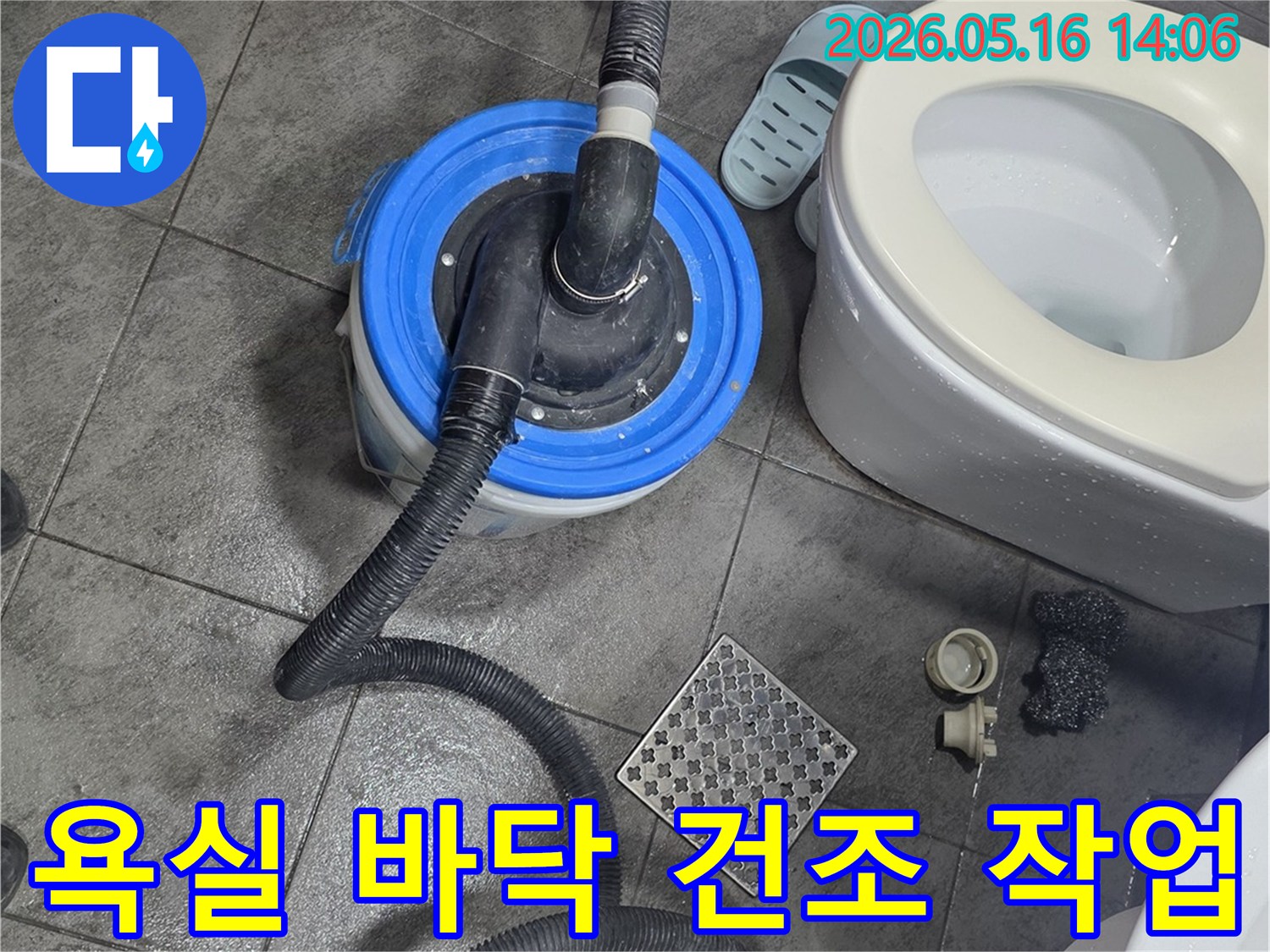 욕실 바닥에-놓인 물 흡입 장비와-변기-그리고 젖은 타일의-누수 복구 작업 현장 모습
