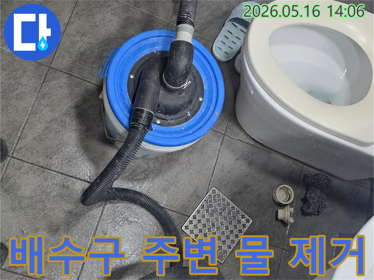 화장실 바닥의-배수구 주변에-놓인 물 흡입 장비와-변기-그리고 젖은 타일의-누수 초기 작업 현장