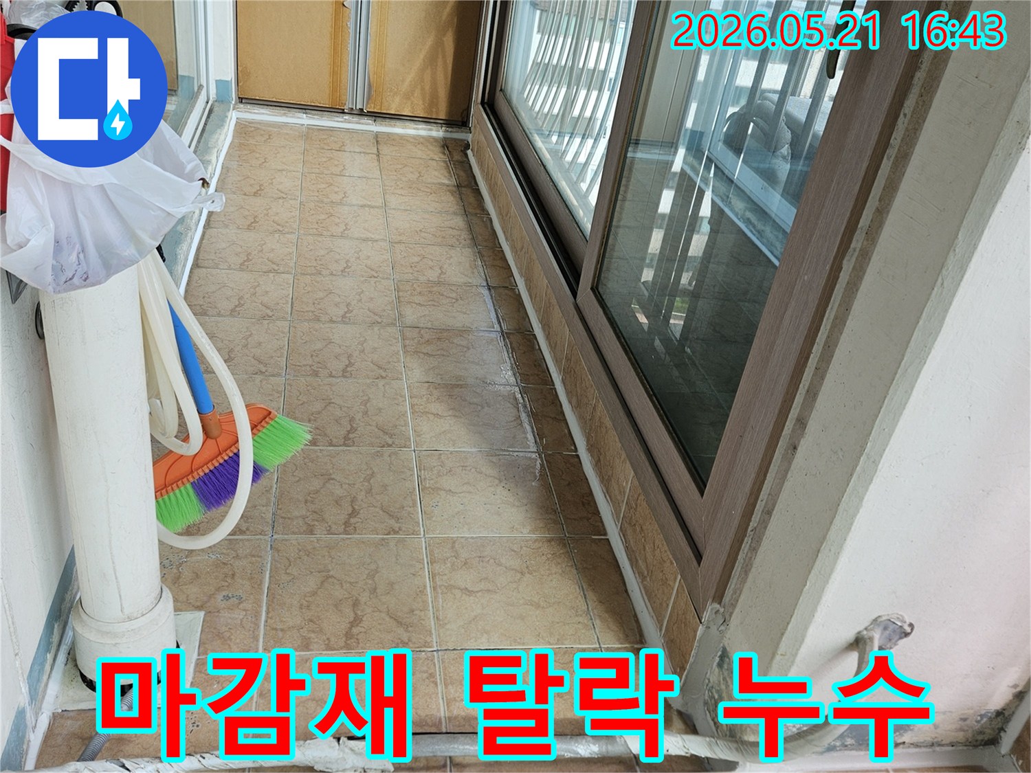 아파트 베란다의 배관 주변 마감재 탈락과-타일 벽면을 보여주며-마감재 문제로 인한 누수 여부를 점검하는 현장입니다.