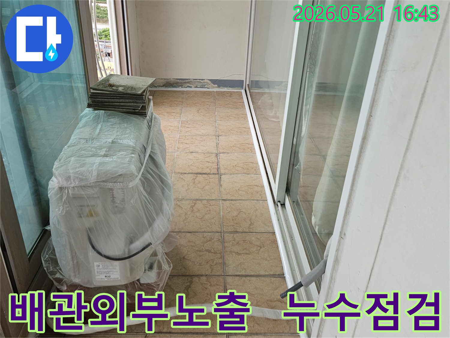 포천-아파트-베란다의-에어컨-실외기-배관-외부-노출-부위에서-누수-여부를-점검하는-모습