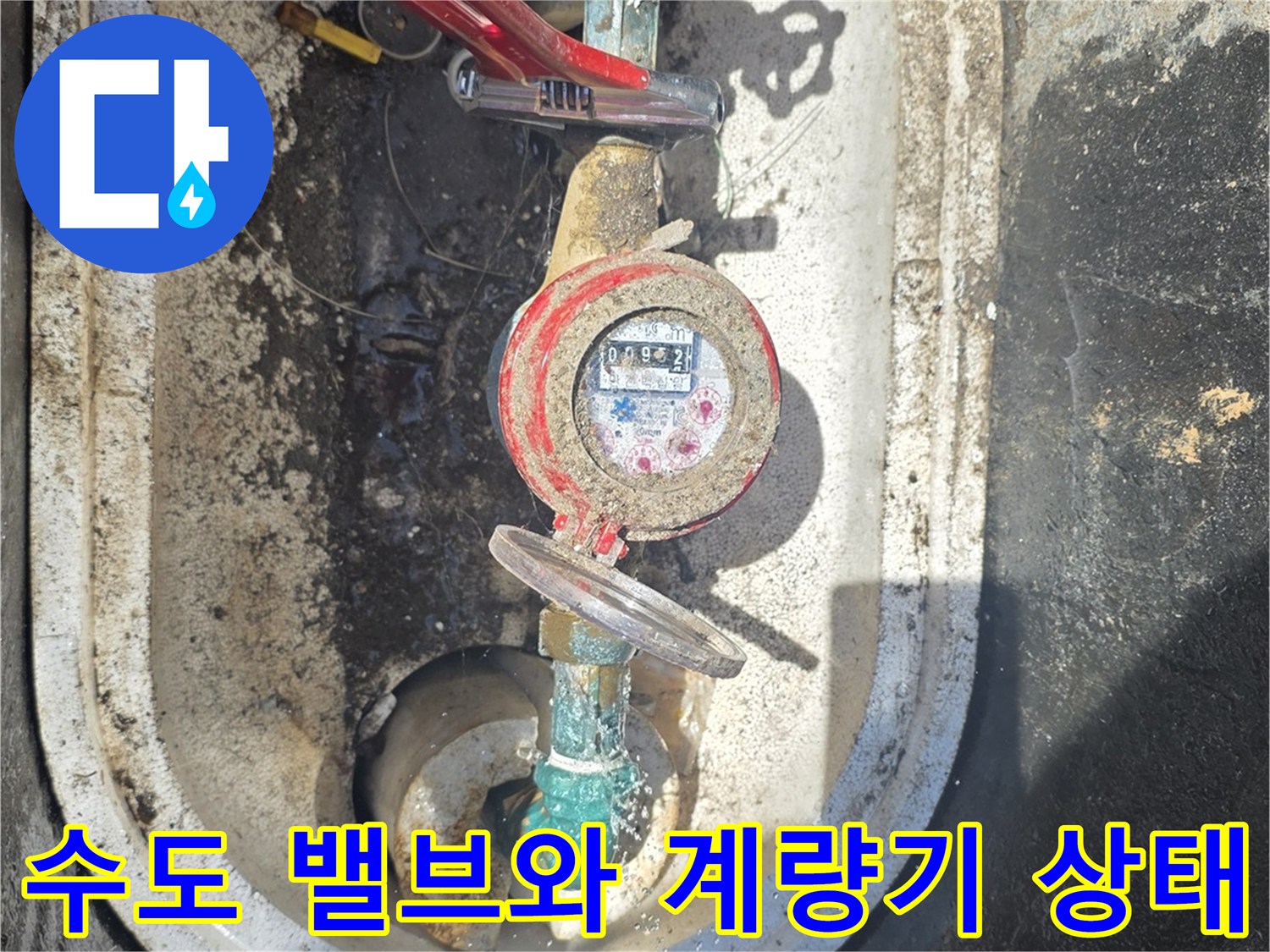 수도 계량기와 붉은색 제어 밸브의 근접 사진