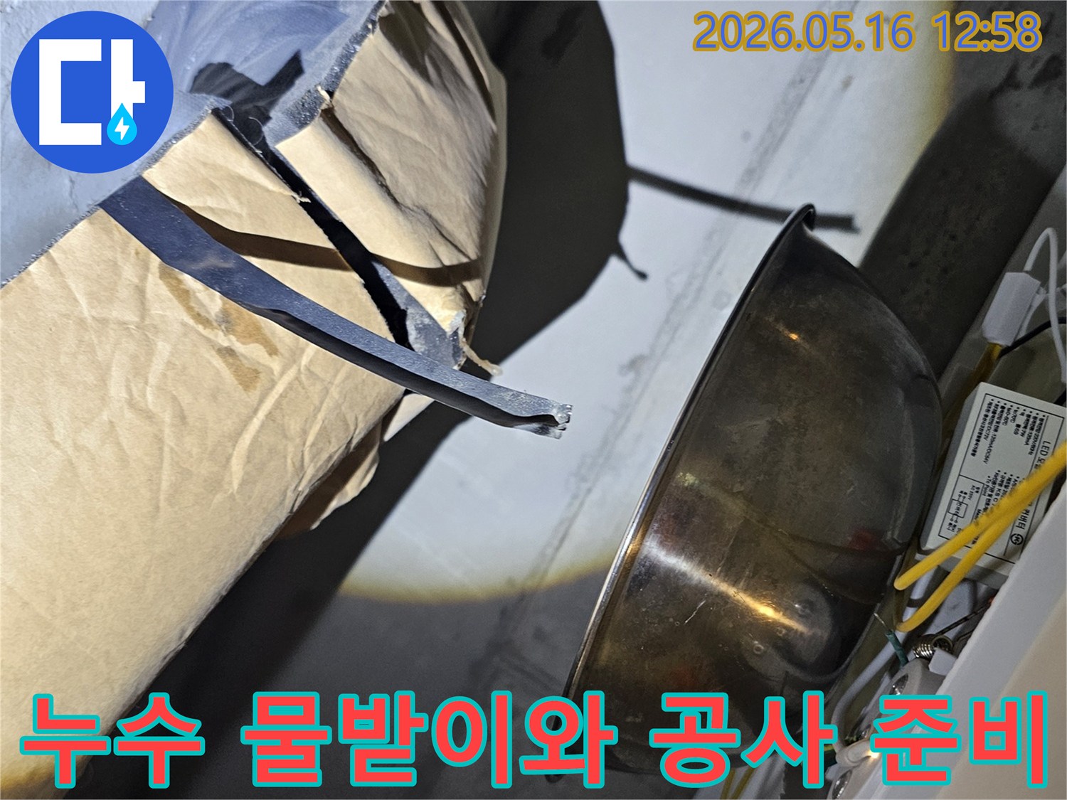 누수-지점에서-떨어지는-물을-임시로-받아내는-금속-그릇과-주변-공사-자재
