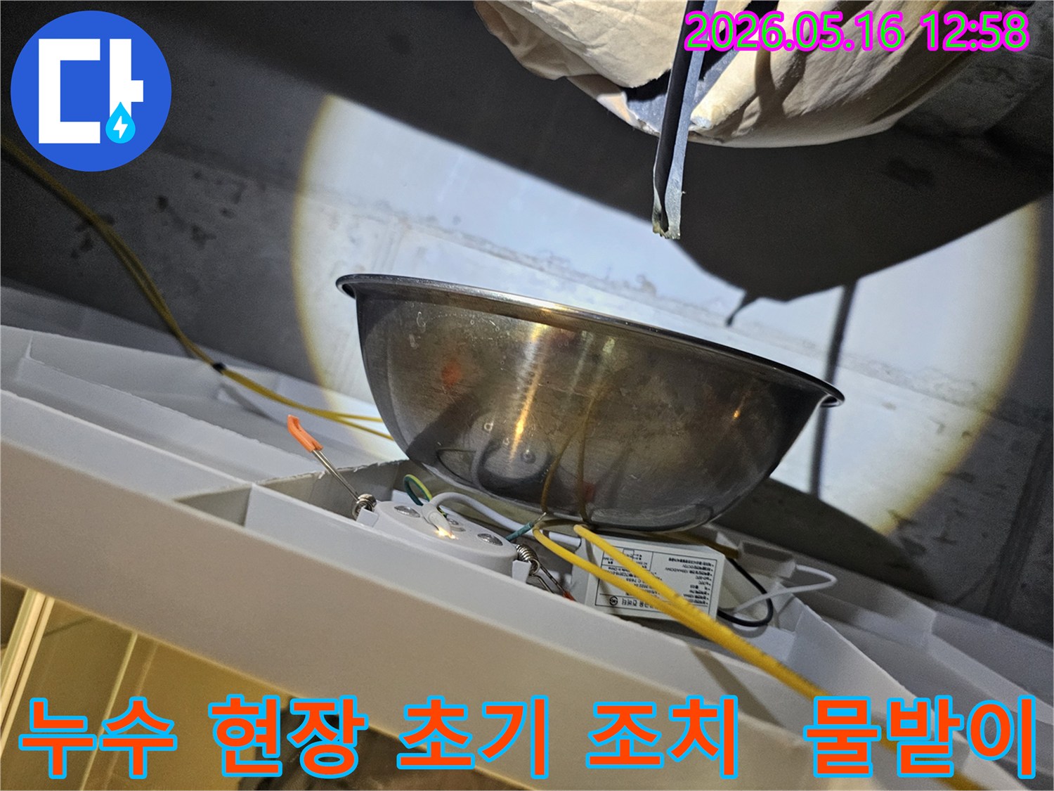누수 현장에서-물이 떨어지는 것을-스테인리스 볼로-받아내며-주변의 노출된 전선과-전기 부품을-보호하는 모습