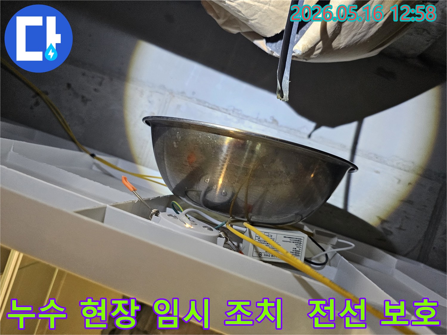 누수 현장에서-물이 떨어지는 것을-스테인리스 볼로-받아내며-주변의 노출된 전선과-전기 부품을-보호하는 모습