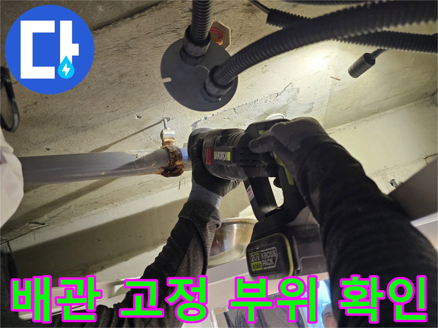 오수관 연결 지점을 전동 드릴로 세밀하게 조사하는 작업 장면