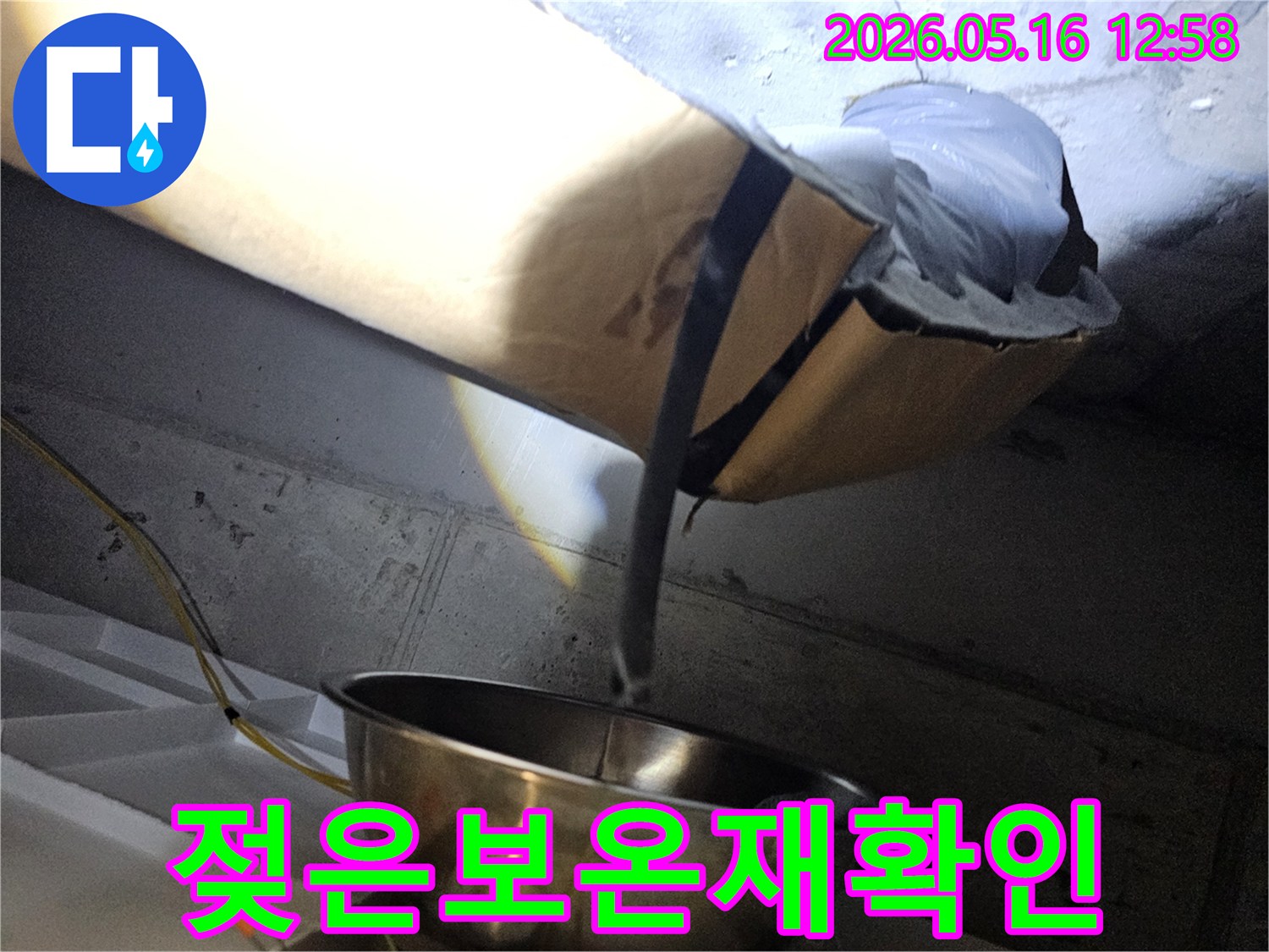 천장 내부의-어두운 공간에서-누수로 인해 젖은-보온재를 조명으로 비춰-확인하는 현장 모습입니다.