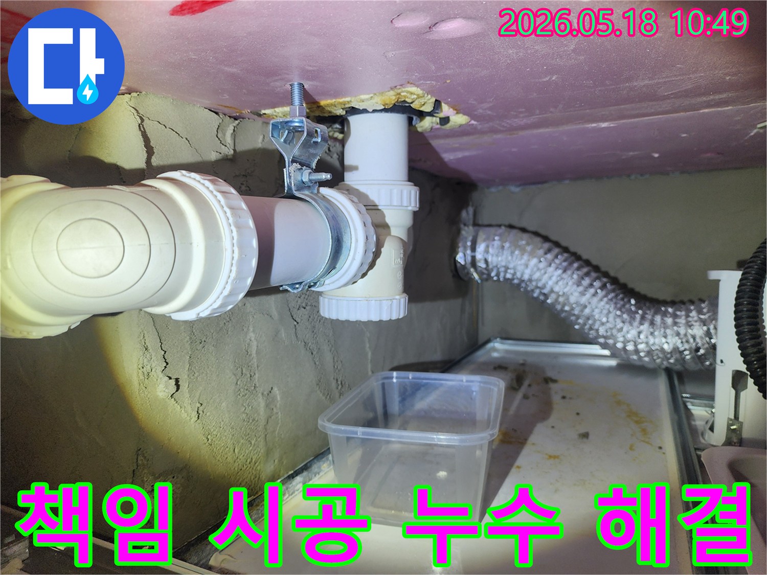 이 사진은 배관 누수 현장에서 물이 떨어지는 것을-임시 용기로 받아내며 완벽한 해결을 위한 책임 시공을 준비하는 모습입니다