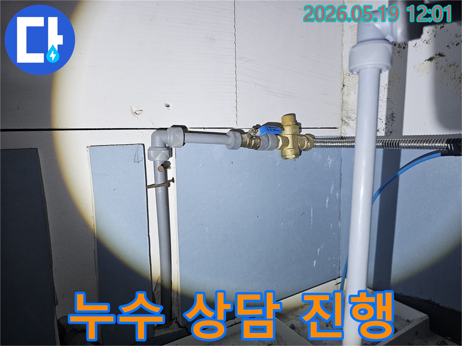 누수 발생 현장의 배관과 밸브를 점검하며-고객에게 누수 원인과 해결 방안을 상세히 설명하는 모습입니다.