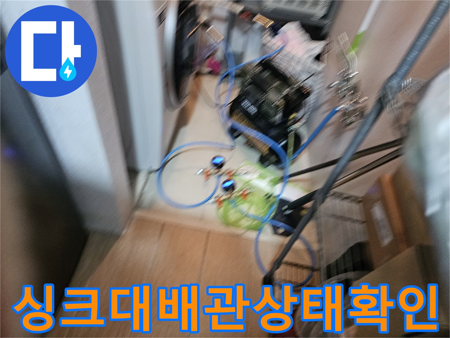 싱크대 하부 공간에 배치된 배관 점검용 전동 장비와 호스입니다.