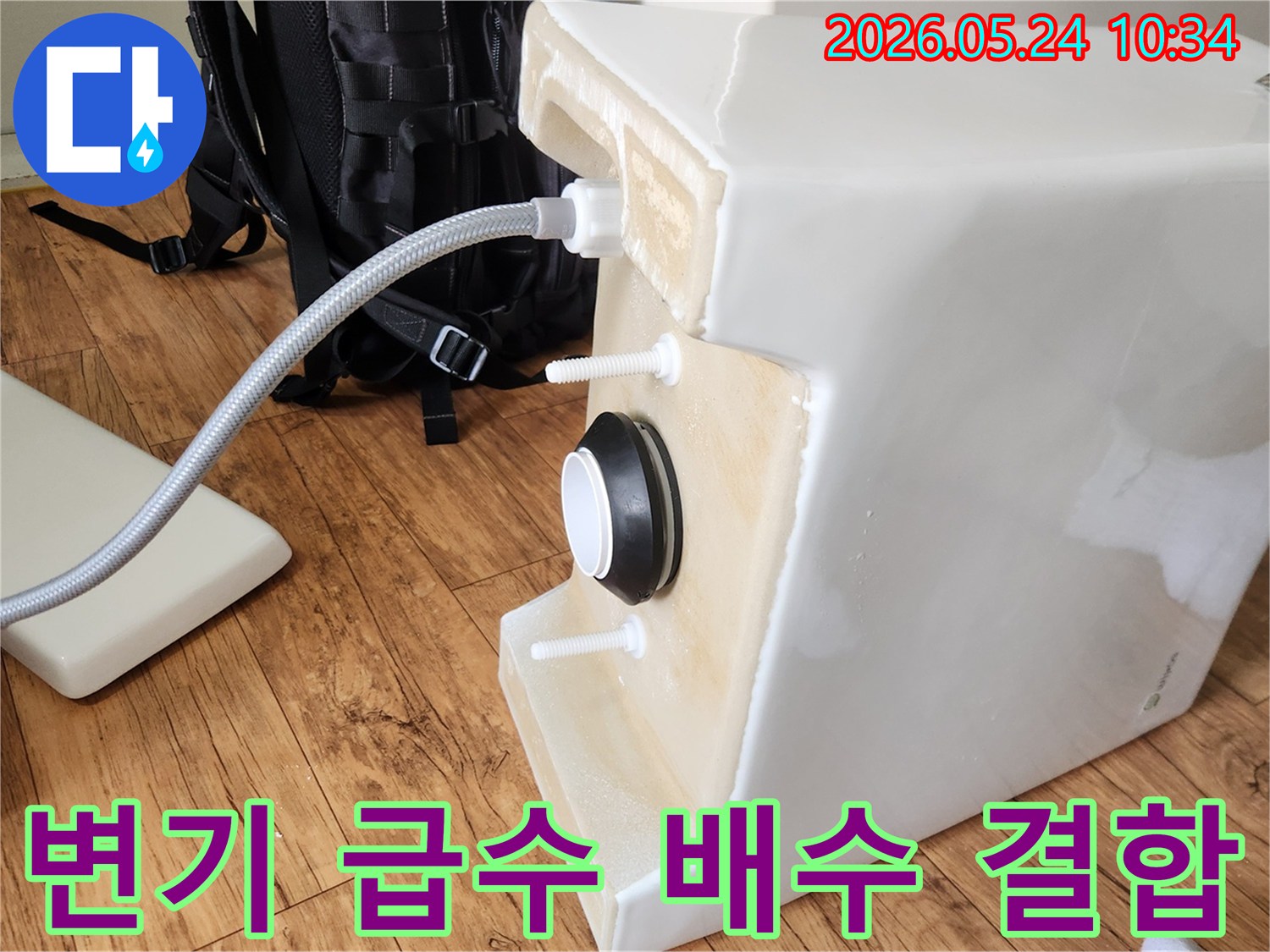 변기 물탱크 하단에-급수 호스와-배수 부속이-깔끔하게-결합되어-물 공급 및 배수 준비를 마친 상태