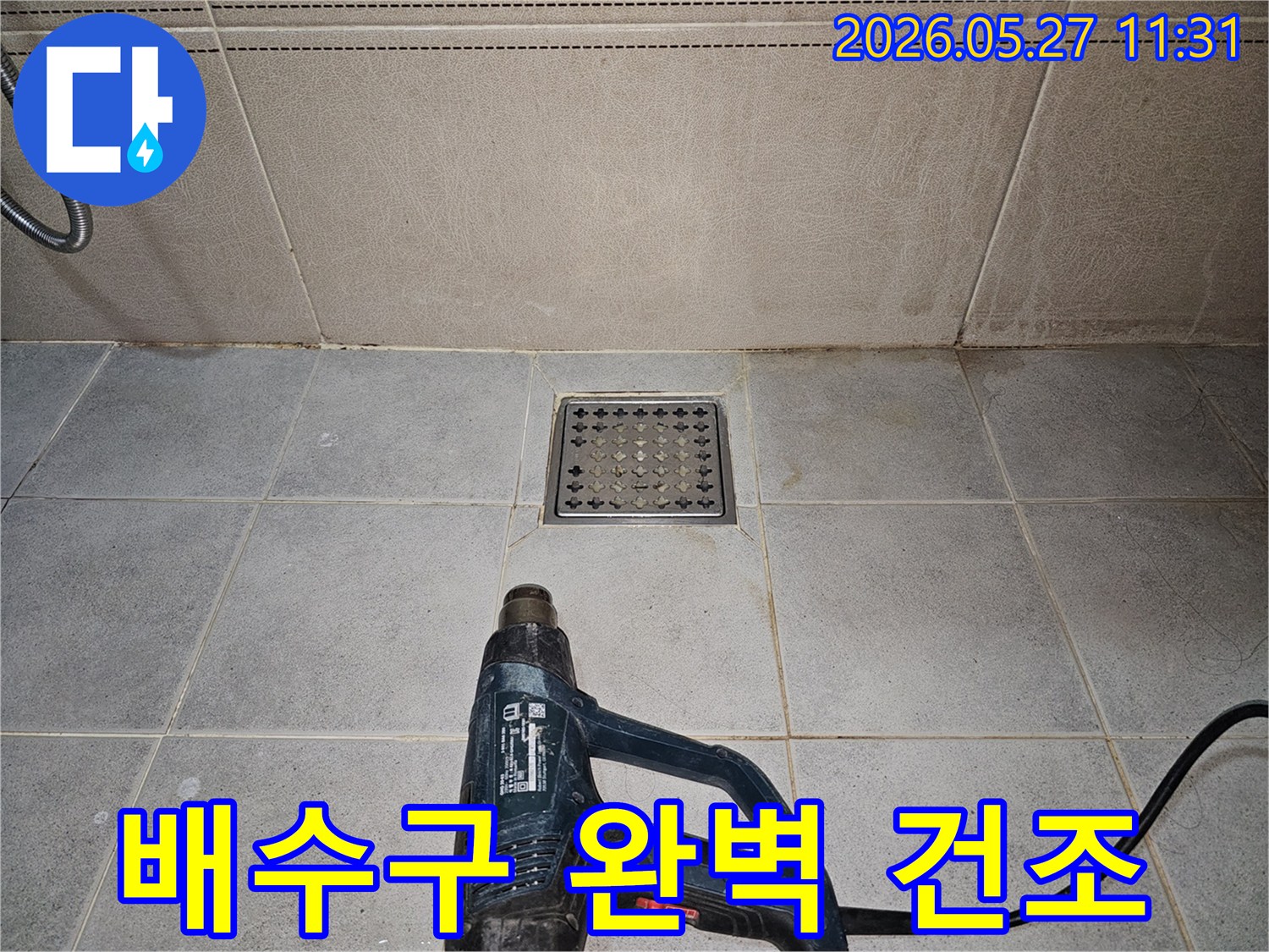 누수 엔지니어가-욕실 배수구 주변을-열풍기로 완벽하게 건조시켜-누수 재발을 방지하고 있습니다