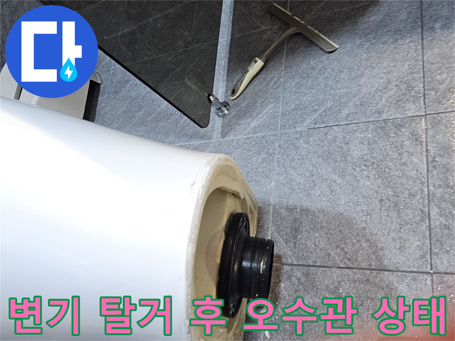 변기를 탈거하여 노출된 화장실 오수관과 검은색 플랜지 부속의 모습입니다.