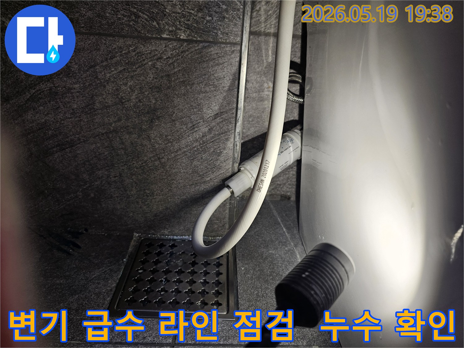 이 사진은-수지구 아파트 화장실에서-변기 급수 라인의 누수 여부를-플래시로 비추며-세밀하게 점검하는 현장을 보여줍니다.