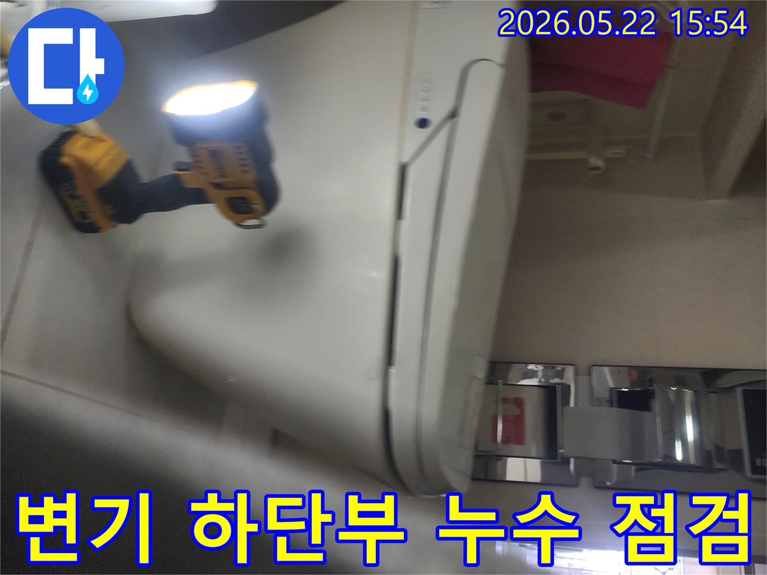 기흥구 아파트 화장실에서-변기 하단부의 누수 여부를-확인하기 위해-작업등을 비추며-정밀하게 점검하는-누수 전문가의 현장 작업