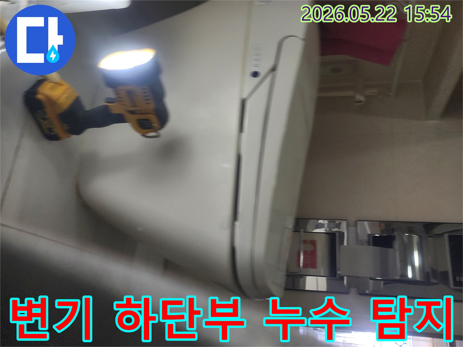 기흥구 아파트 화장실에서-변기 하단부의 누수 여부를-확인하기 위해-작업등을 비추며-정밀하게 탐지하는-누수 전문가의 현장 작업