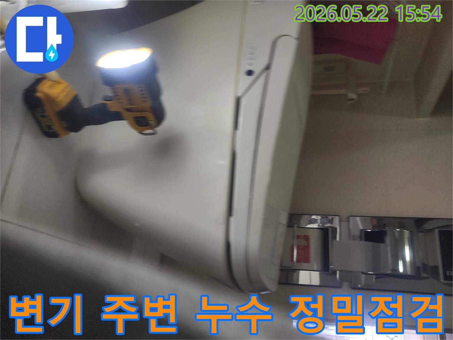 용인 보정동 화장실에서-변기 주변의 누수 여부를-정밀하게 점검하기 위해-작업등을 비추며-세심하게 확인하는-누수 전문가의 현장 작업