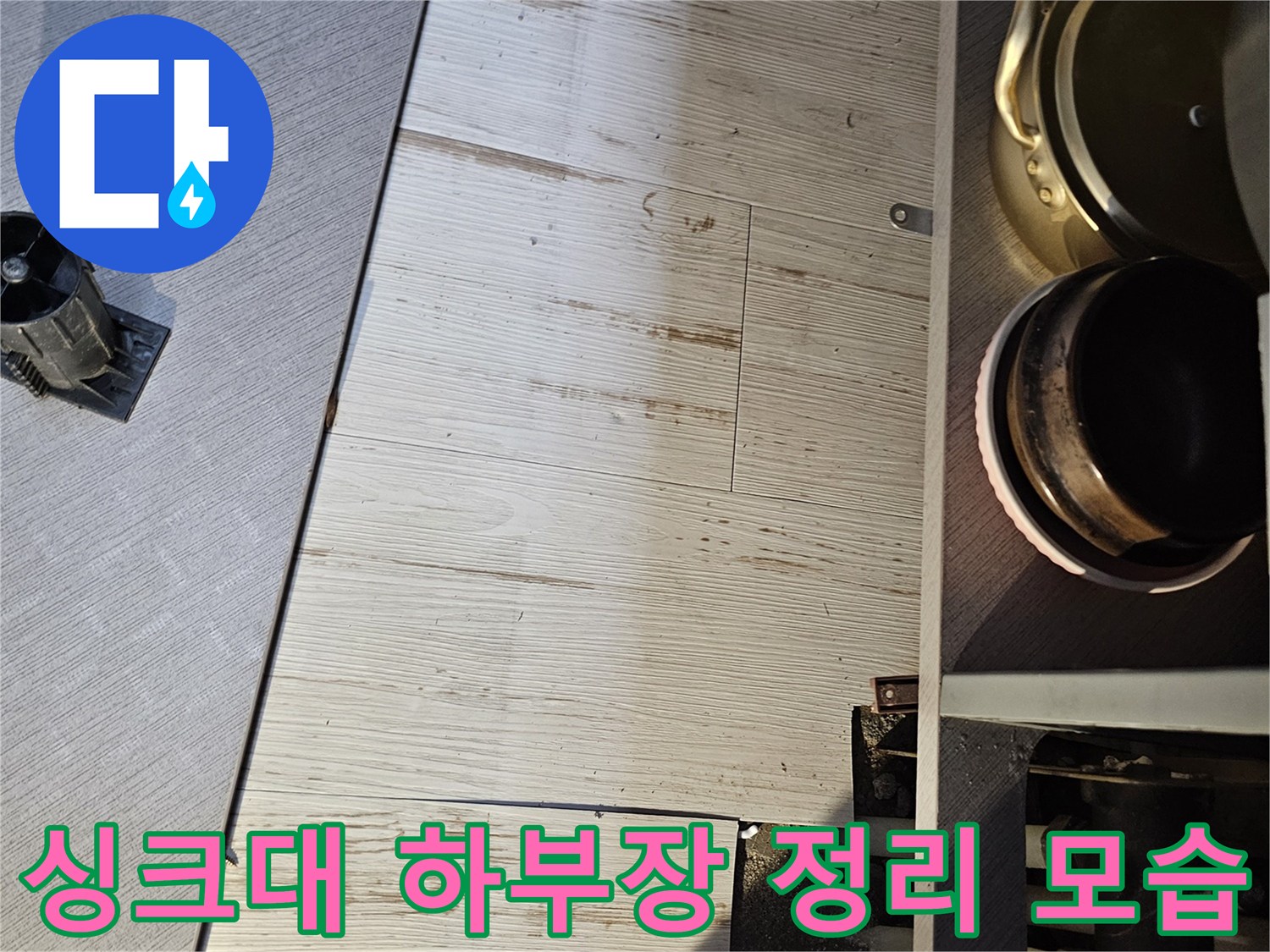 누수 점검을 위해 싱크대 하부 수납물을 비우고 작업 공간을 확보한 상태입니다.