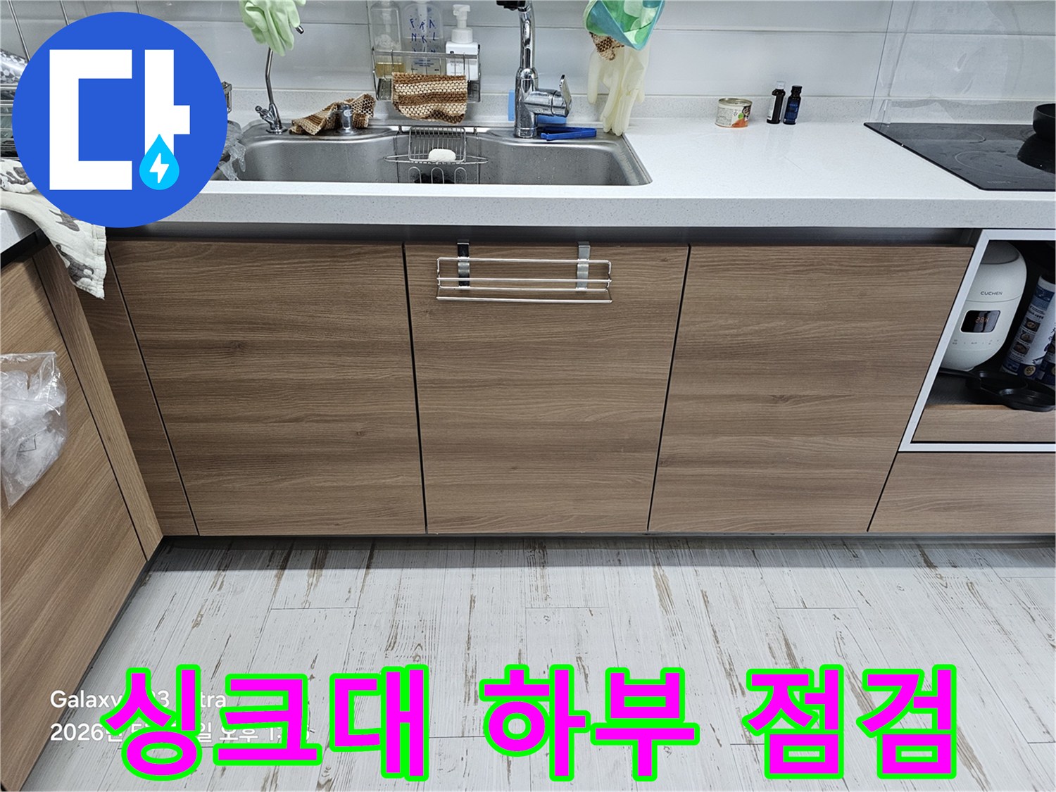 누수 탐지를 위해 비워진 싱크대 하부장과 주변 환경 - 현장 진단 모습