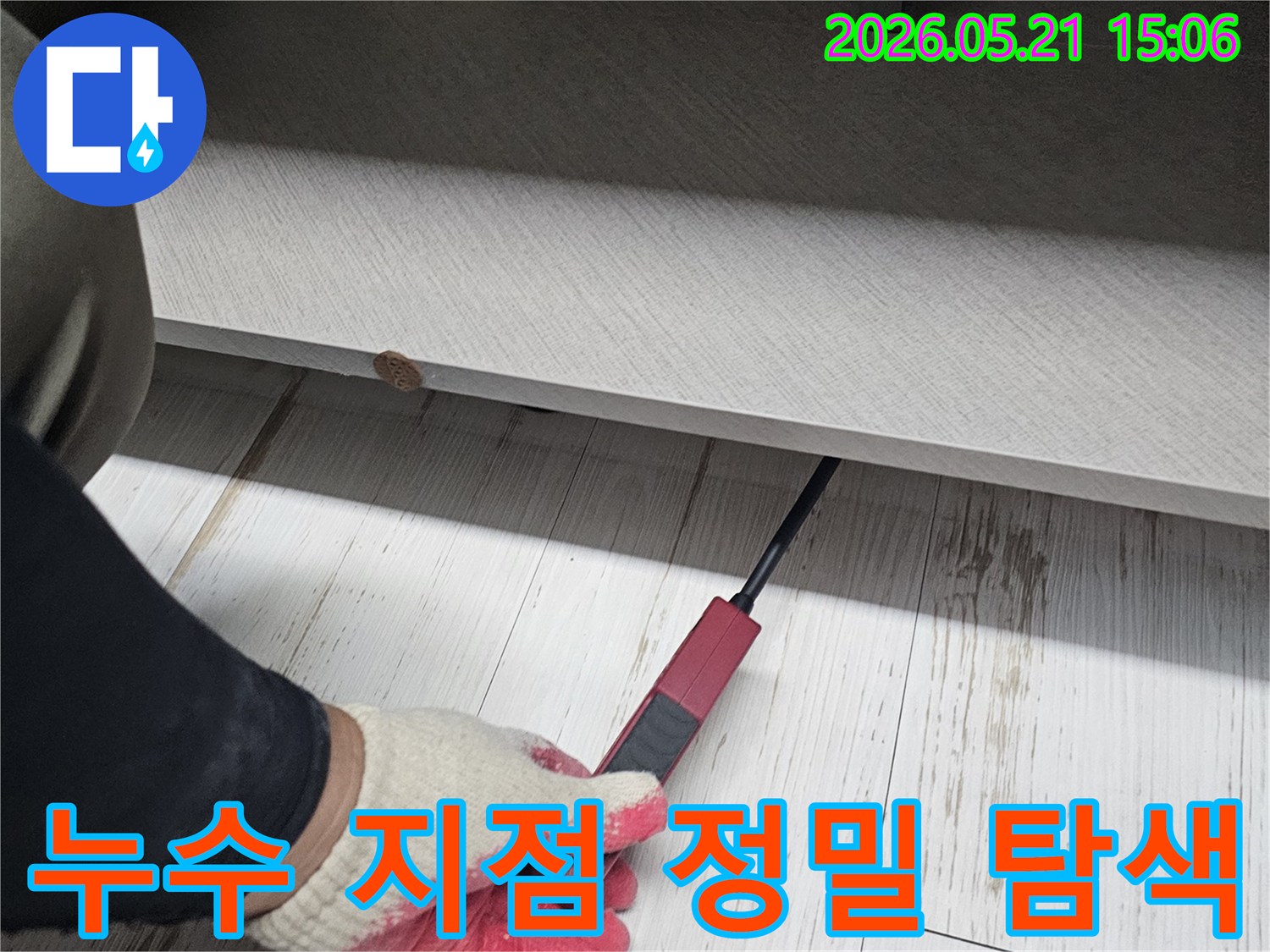 숙련된-엔지니어가-누수-탐지기를-활용하여-가구-틈새의-누수-지점을-정밀하게-조사하는-장면입니다