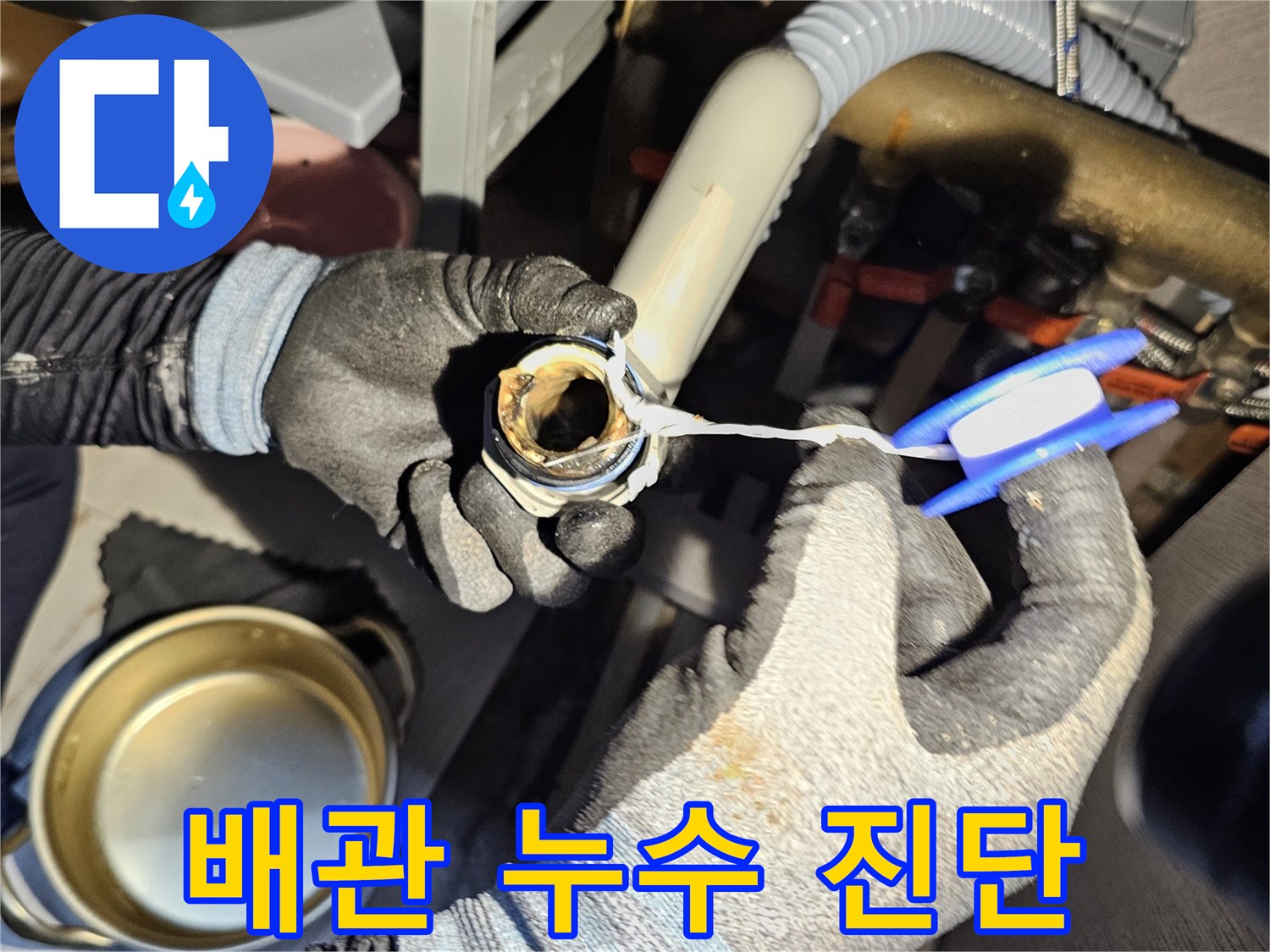 작업자가 싱크대 하단 배관 부위를 손으로 직접 만져보는 모습