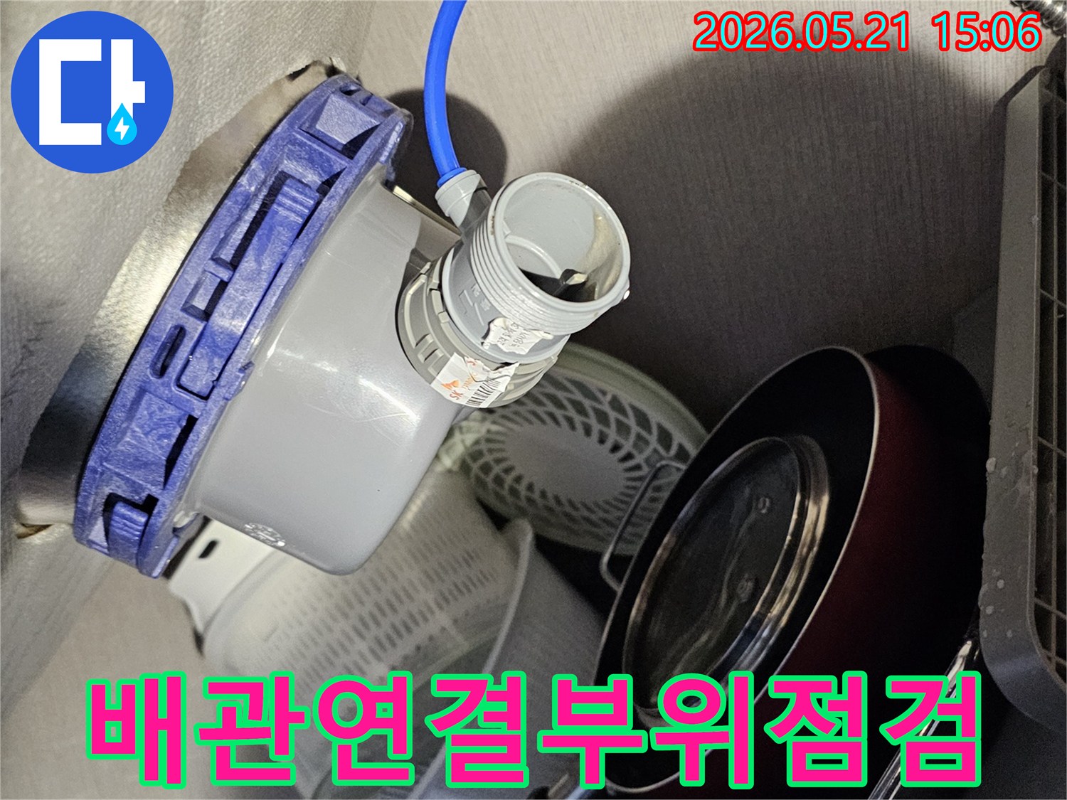 주방-싱크대-하부장-배관-연결부위에서-누수-흔적을-찾기-위해-집중적으로-점검하는-전문가의-모습